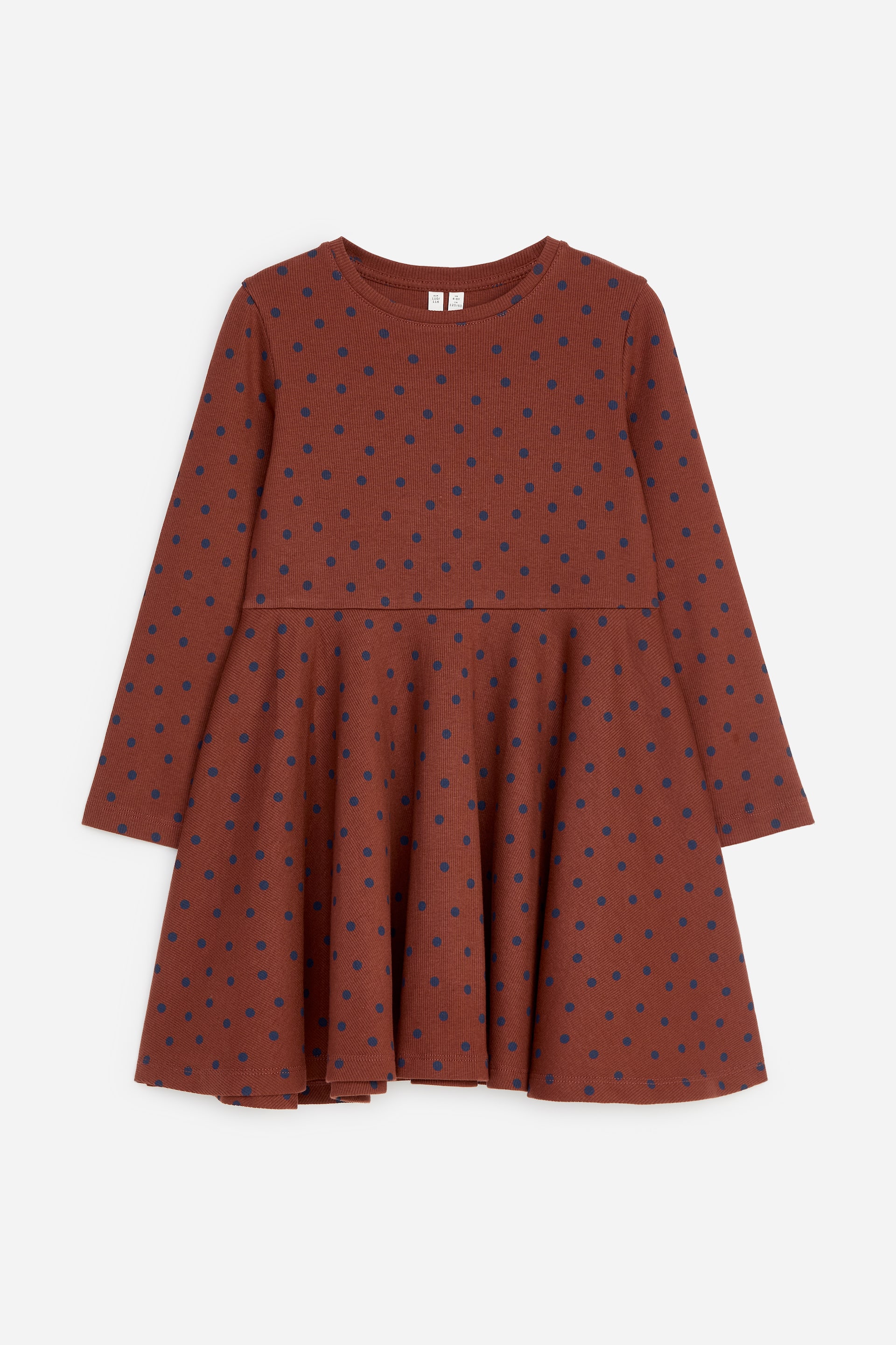 View larger image: A long-sleeved, rust-coloured ribbed knit dress is displaying a pattern of small dark blue polka dots, showcased from the front. It features a round neckline and a flared skirt that flows from a horizontal seam below the bodice.