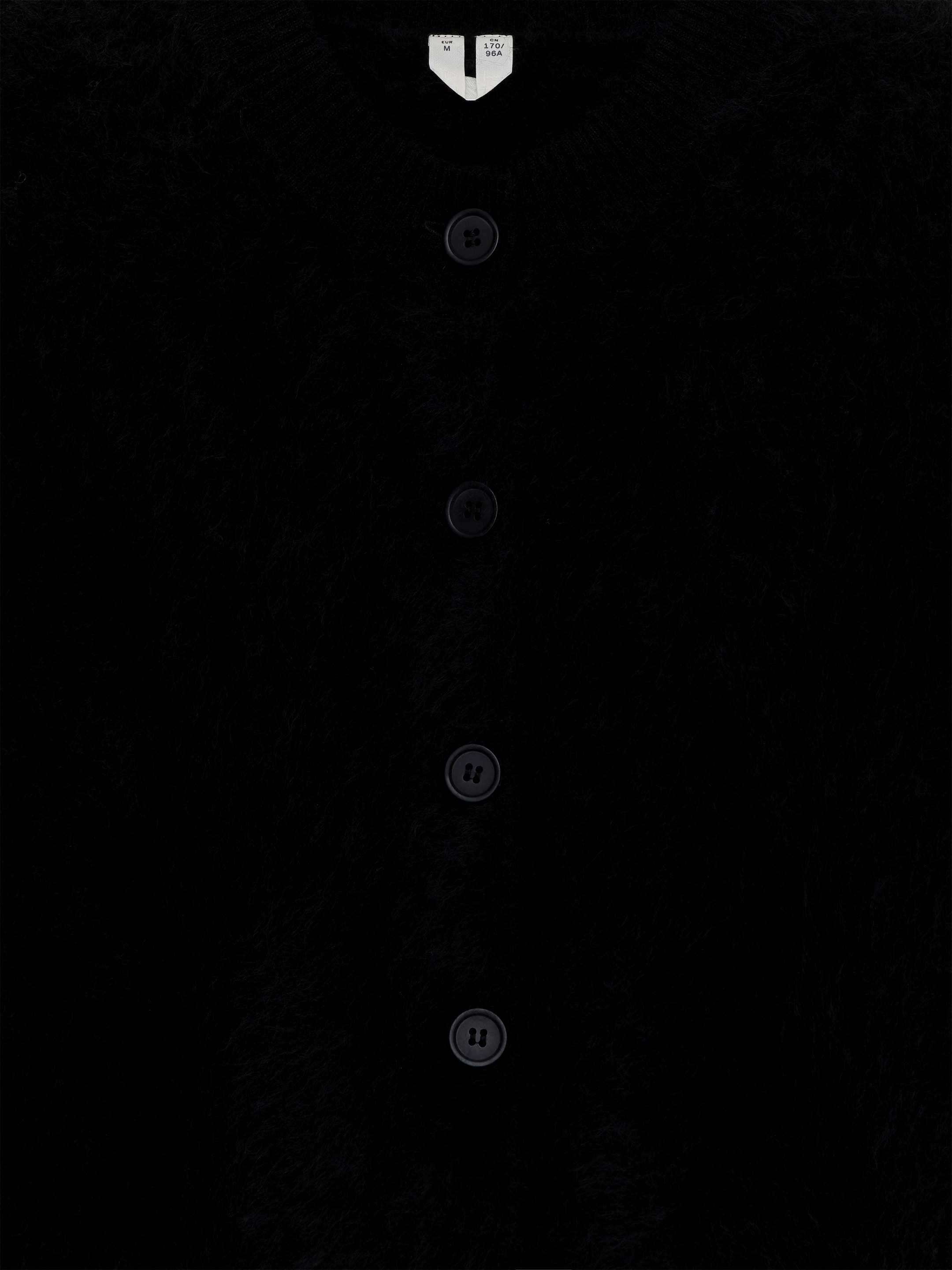 Agrandir l'image: Un cardigan noir en cachemire brossé pur est présenté de face, affichant une texture douce et brossée. Plusieurs boutons sombres et ronds descendent le long du centre, et une étiquette de taille blanche est visible en haut.