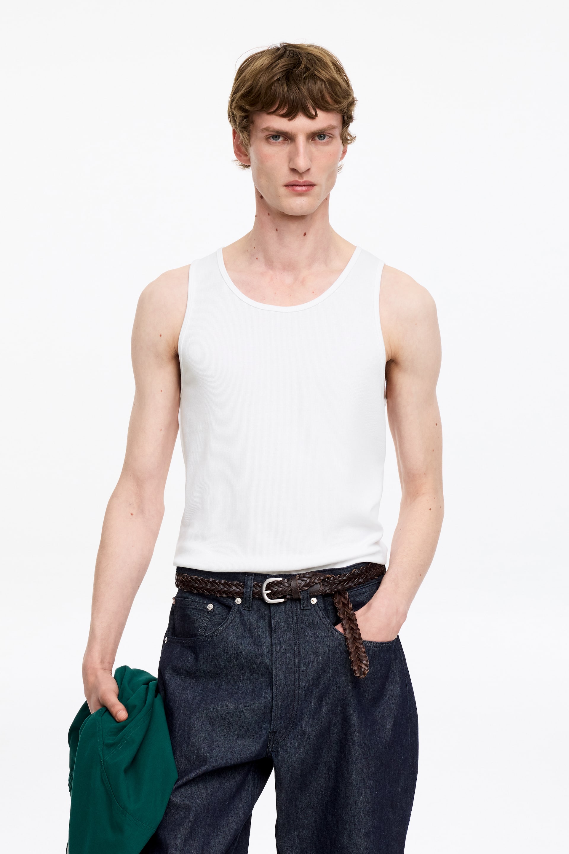 Größeres Bild ansehen: Ein weißes geripptes Tanktop mit Rundhalsausschnitt und enger Passform. Es wird frontal präsentiert.