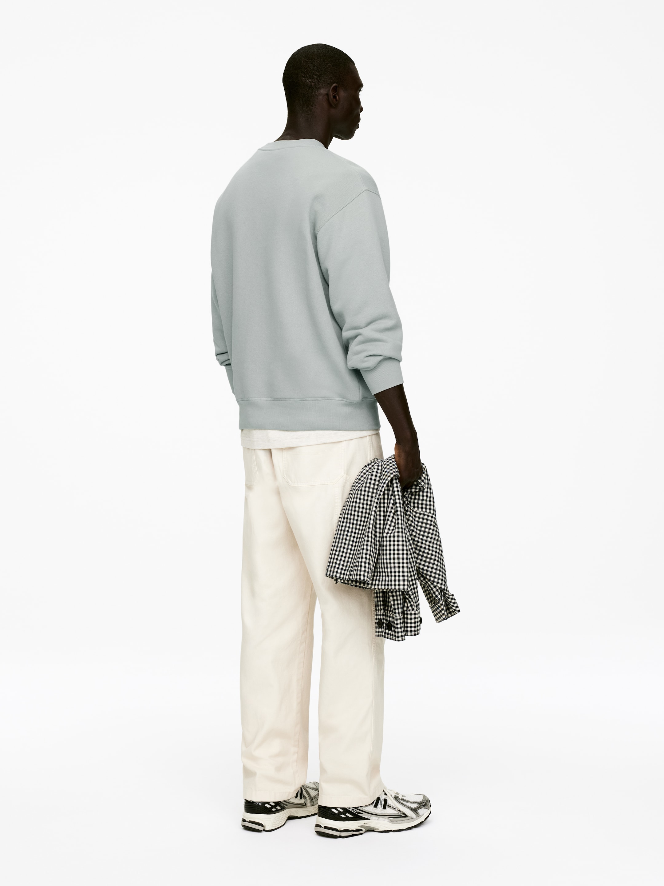 Agrandir l'image: Un sweat-shirt bleu-gris pâle à col rond est présenté de dos, mettant en valeur sa coupe décontractée, ses manches longues avec poignets côtelés et un ourlet côtelé.