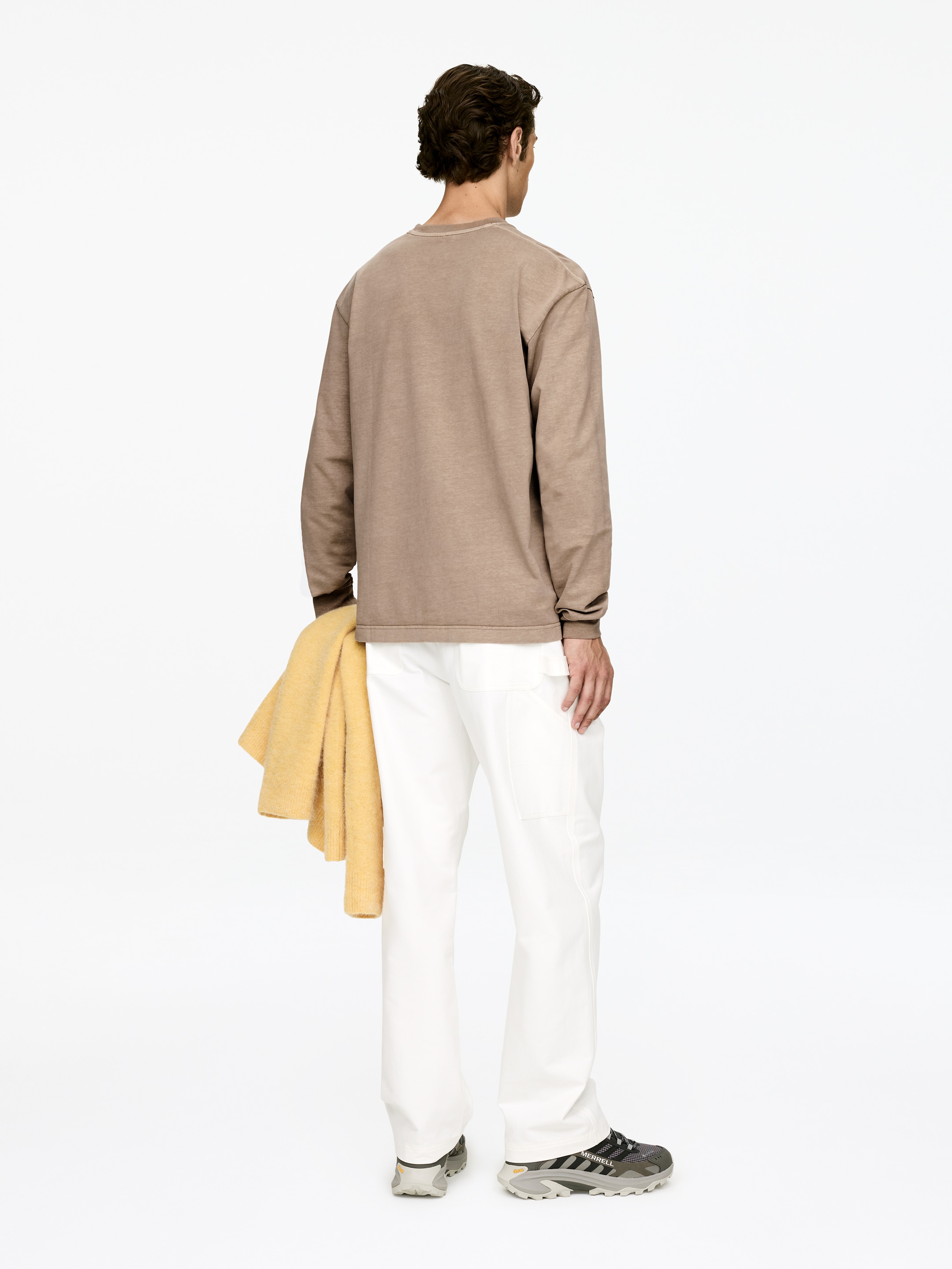 Agrandir l'image: Un T-shirt à manches longues de couleur brun clair, conçu en coton, avec un col rond classique et des manches retroussées, est porté par le modèle.