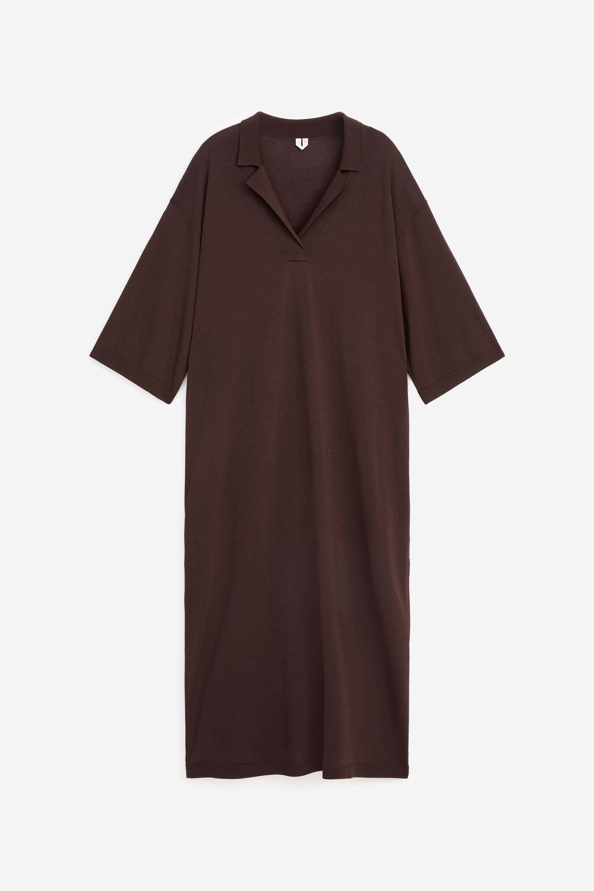 Größeres Bild ansehen: Ein dunkelbraunes Strickkleid präsentiert sich von vorne in einer lockeren, geraden Passform. Es zeigt einen Umlegekragen mit V-Ausschnitt, weite Dreiviertelärmel und einen geraden Saum.