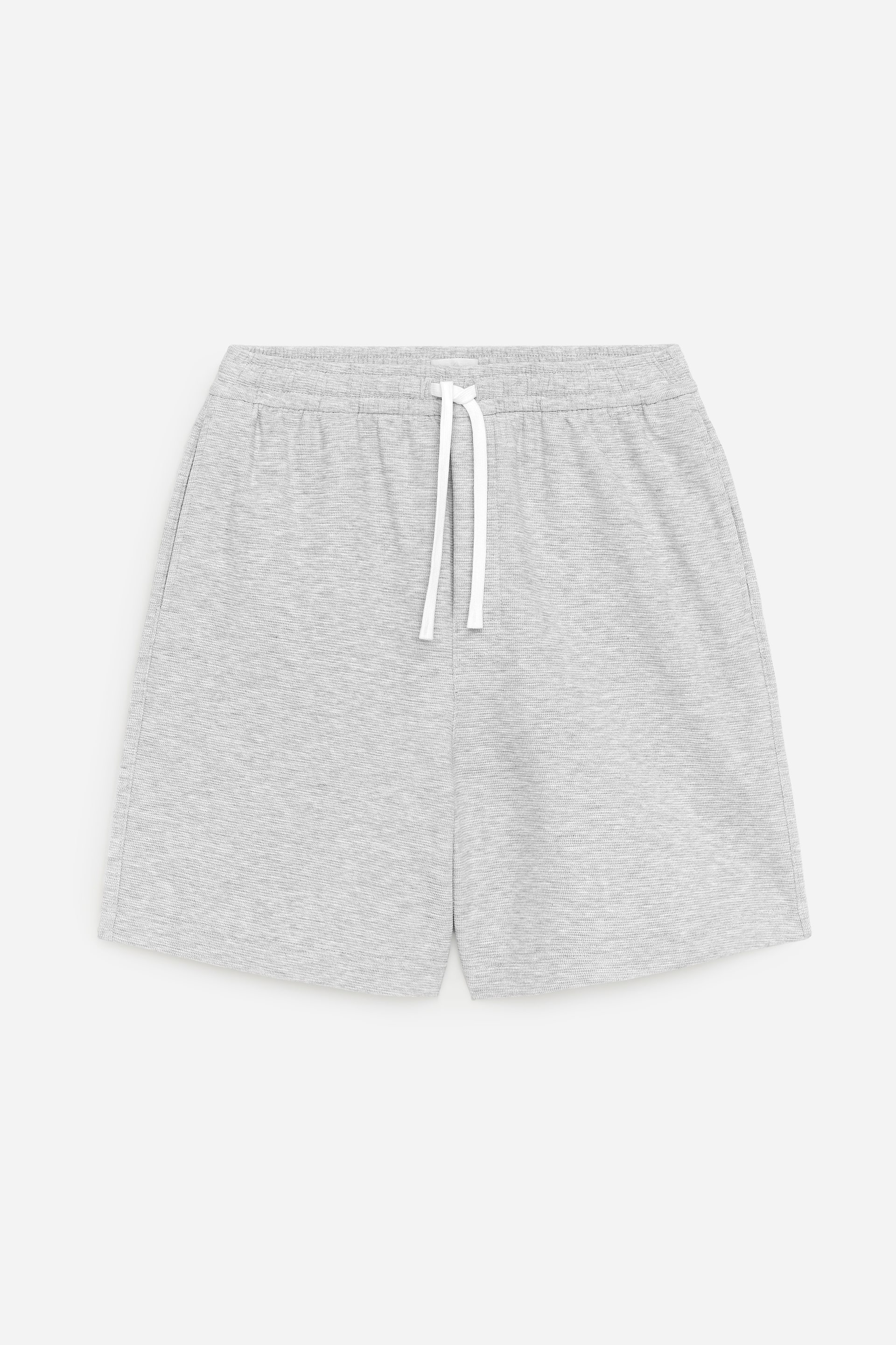 Agrandir l'image: Shorts en jersey gris clair affichant une vue de face, avec une taille élastiquée dotée d'un cordon plat blanc, une braguette factice cousue et des poches latérales dans les coutures. Le tissu présente une surface subtilement texturée.
