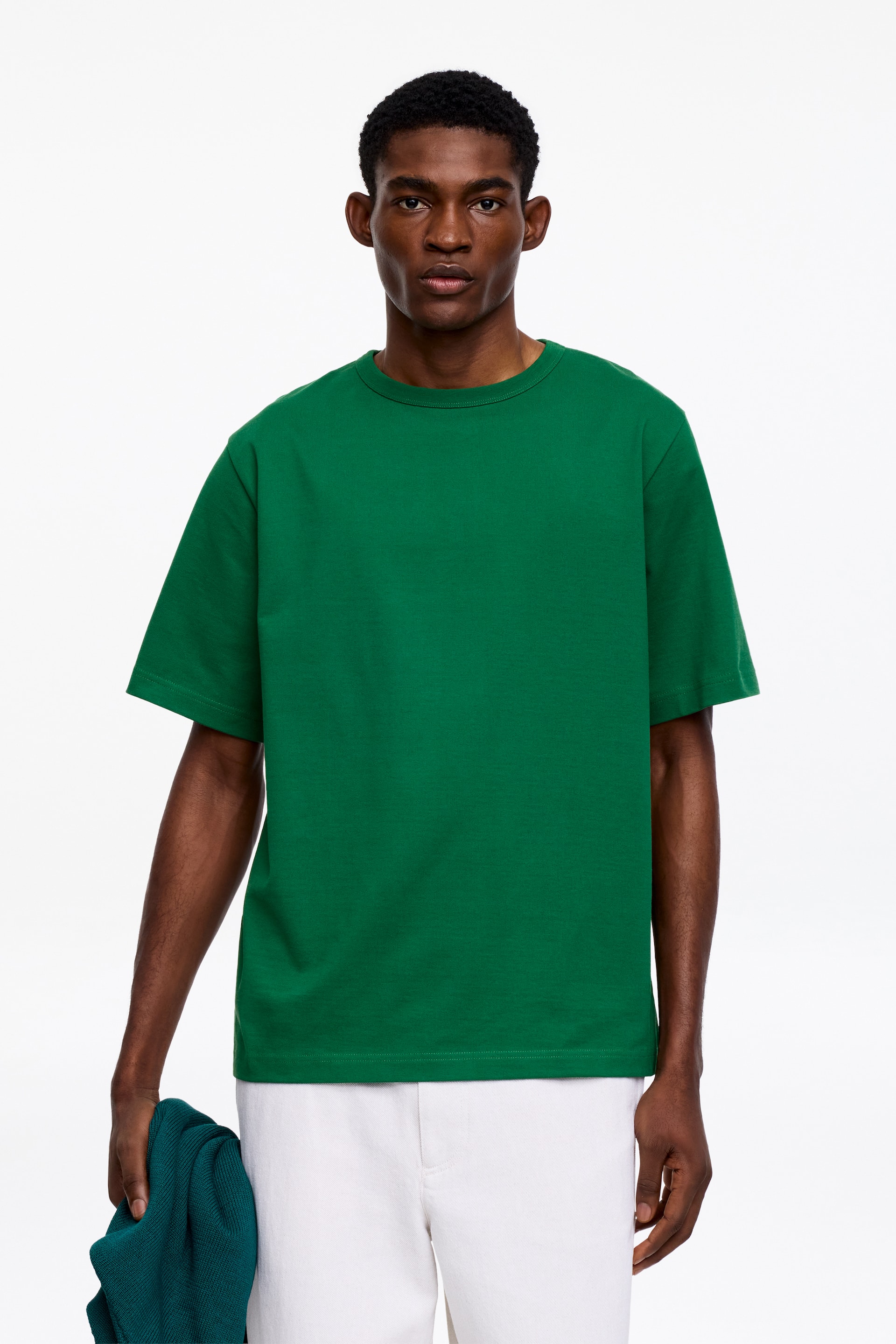 Vis større bilde: En solid grønn t-skjorte med rund hals vises forfra, med korte ermer, en avslappet passform og en glatt tekstur.