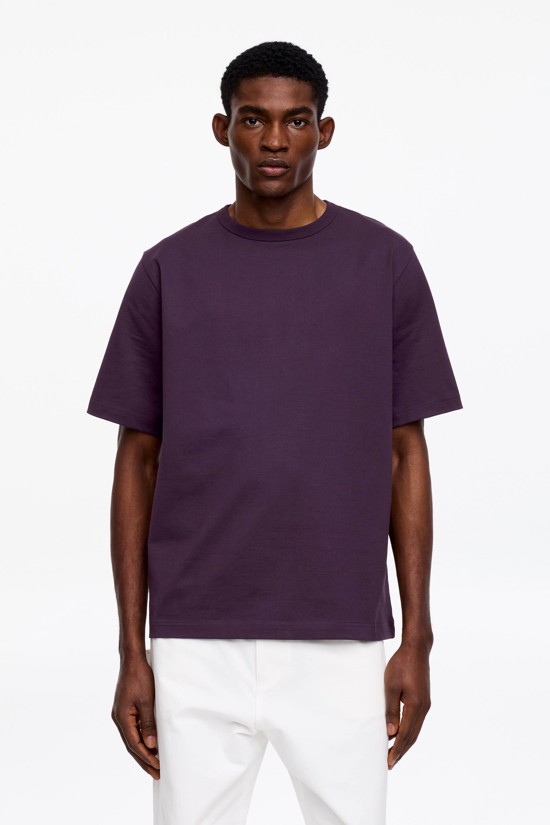 Grotere afbeelding bekijken: Een donkerpaarse t-shirt met een geribbelde ronde hals en korte mouwen. Het heeft een ontspannen pasvorm met een rechte zoom en wordt getoond vanuit een frontale hoek.