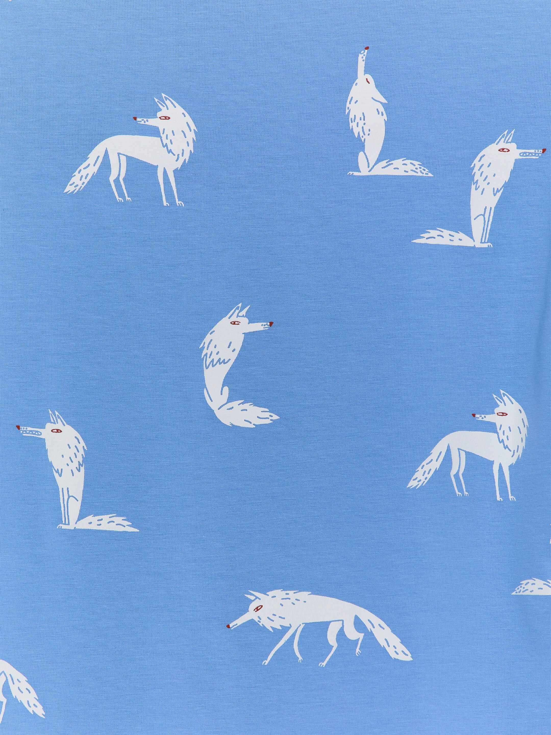 Agrandir l'image: Le tissu du pyjama est en jersey de coton léger bleu clair, arborant un motif répétitif de renards de style cartoon blancs avec des yeux et des nez rouges dans diverses poses.