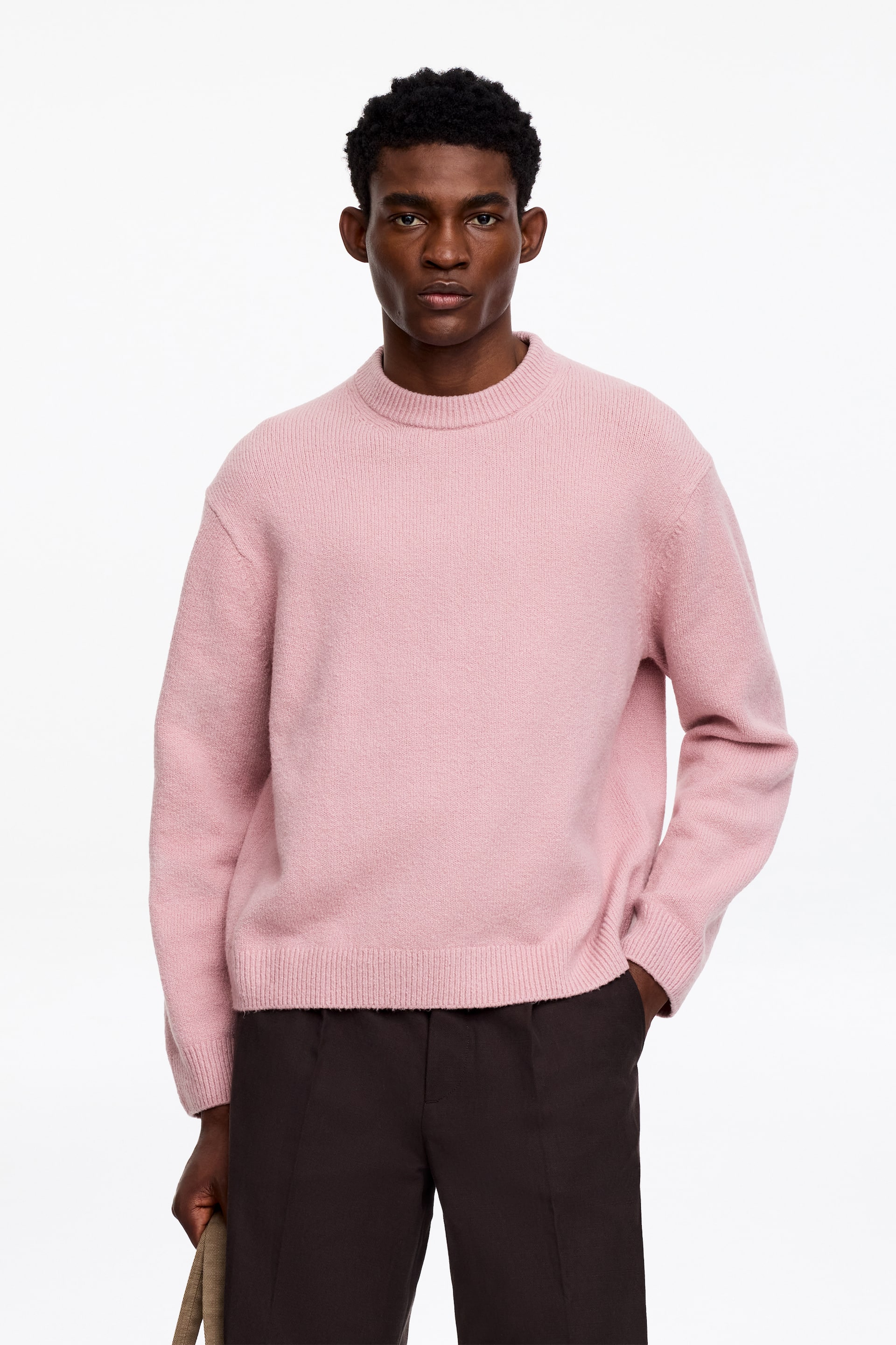 Visa större bild: En rosa tröja med rund hals har en mjuk, borstad stickad textur, synlig framifrån. Den har en avslappnad passform med långa ärmar, ribbade muddar och en ribbad fåll.