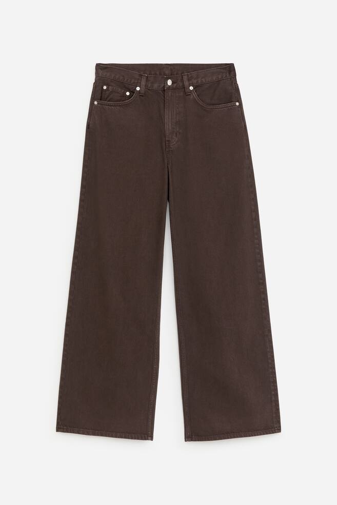 Brown denim jeans are presented FRONT, featuring a relaxed fit and loose legs. They showcase a button fastening at the waist, belt loops, and curved front pockets. - 1
