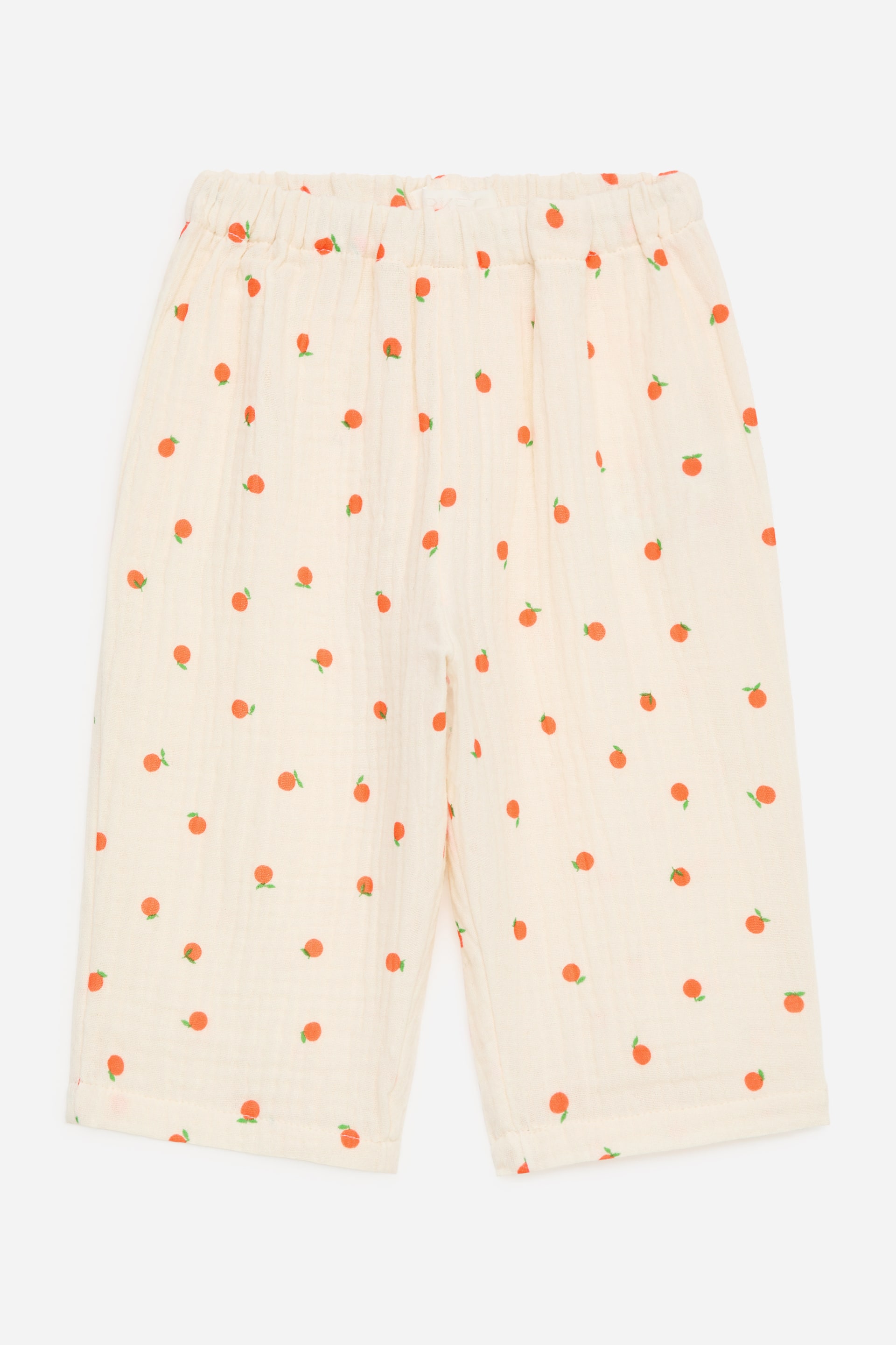 Größeres Bild ansehen: Locker geschnittene Hosen werden von vorne gezeigt, aus einem weichen, cremeweißen Musselin-Gewebe gefertigt, das ein durchgehendes Muster aus kleinen orangefarbenen Früchten mit grünen Blättern aufweist, und einen elastischen, gerafften Bund hat.