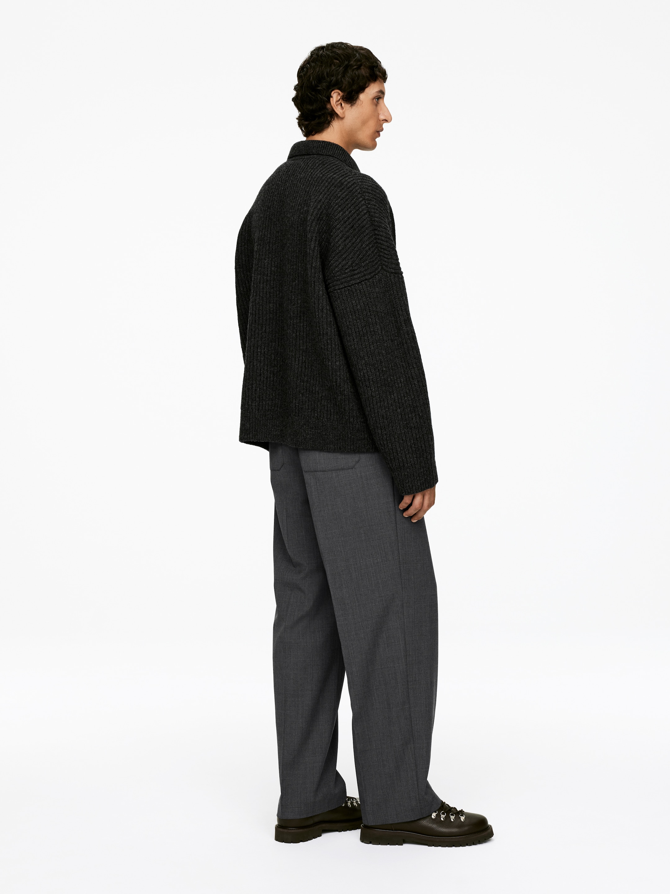 Ingrandisci l'immagine: Pantaloni di lana di colore grigio scuro, con una vestibilità regolare e tasche laterali, sono indossati dalla modella.