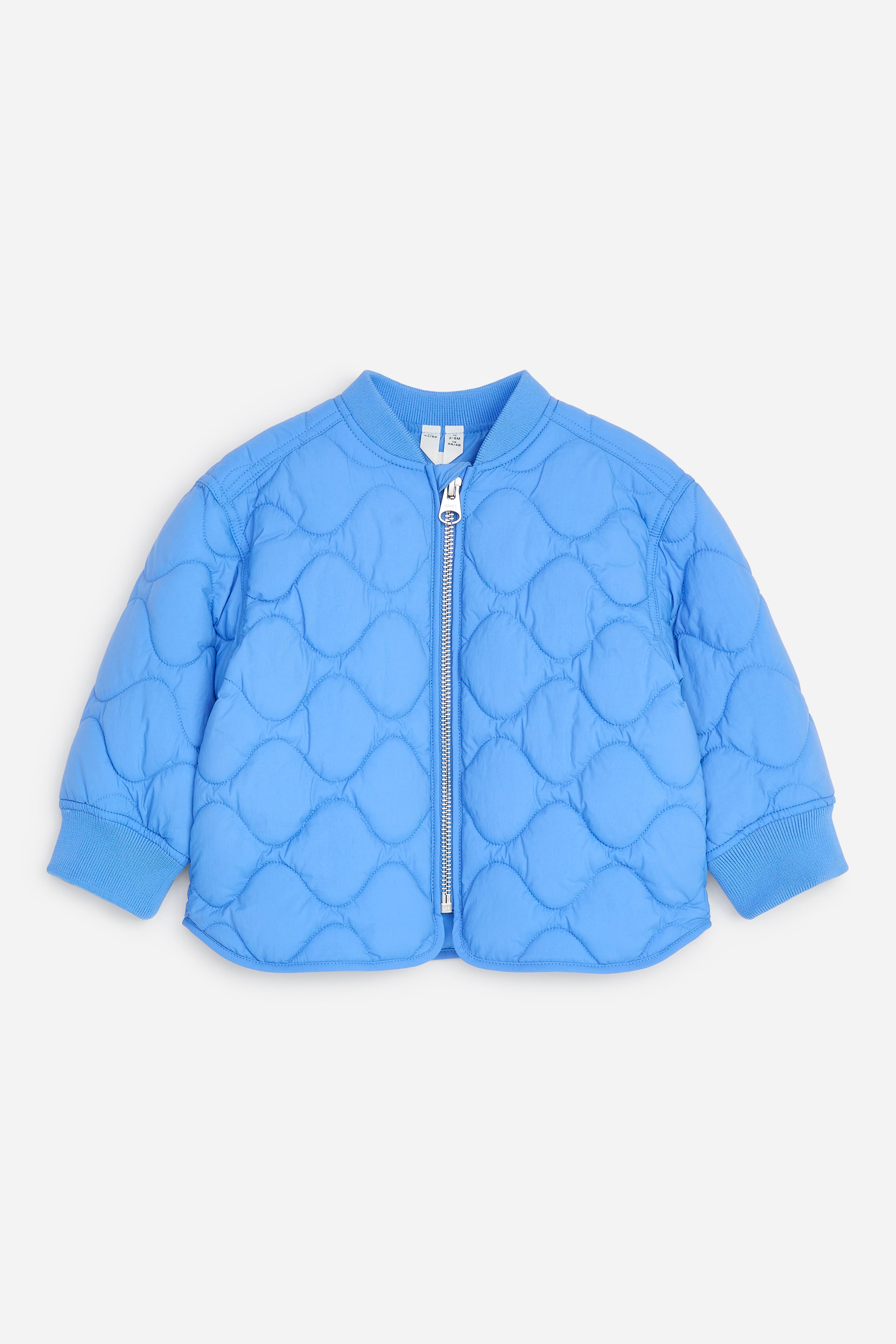 Visualizza l'immagine ingrandita: Una giacca bomber trapuntata blu è mostrata in vista frontale, mettendo in evidenza un motivo trapuntato ondulato su corpo e maniche. Presenta un colletto a coste, polsini a coste e una zip color argento che scorre lungo il centro sul davanti.
