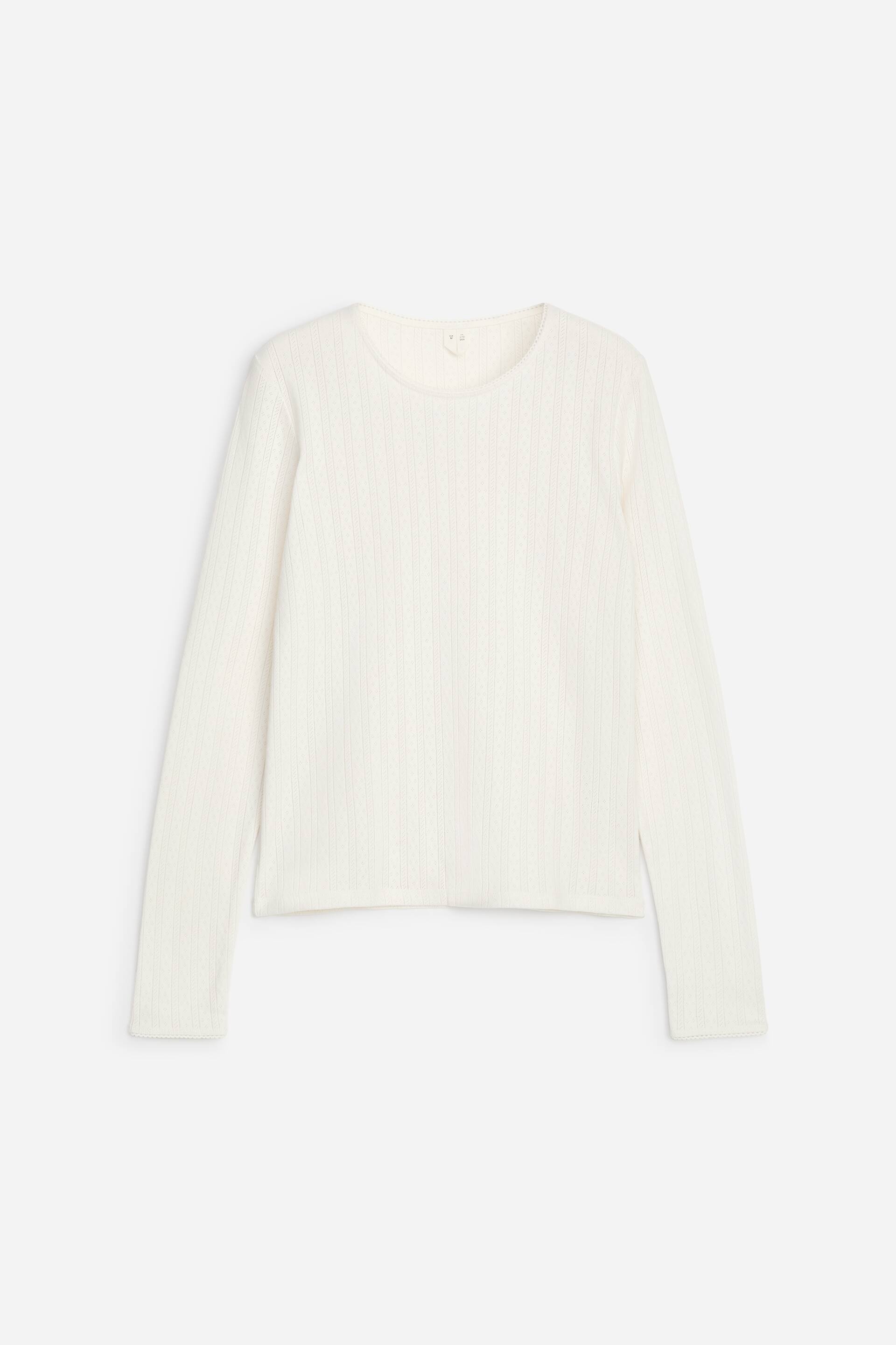 Vezi imaginea mai mare: O bluză cu mâneci lungi, de culoare alb-deschis, este prezentată din față, evidențiind un model delicat de tricot pointelle pe verticală. Bluza are un decolteu rotund și margini discrete festonate la decolteu, manșete și tiv.
