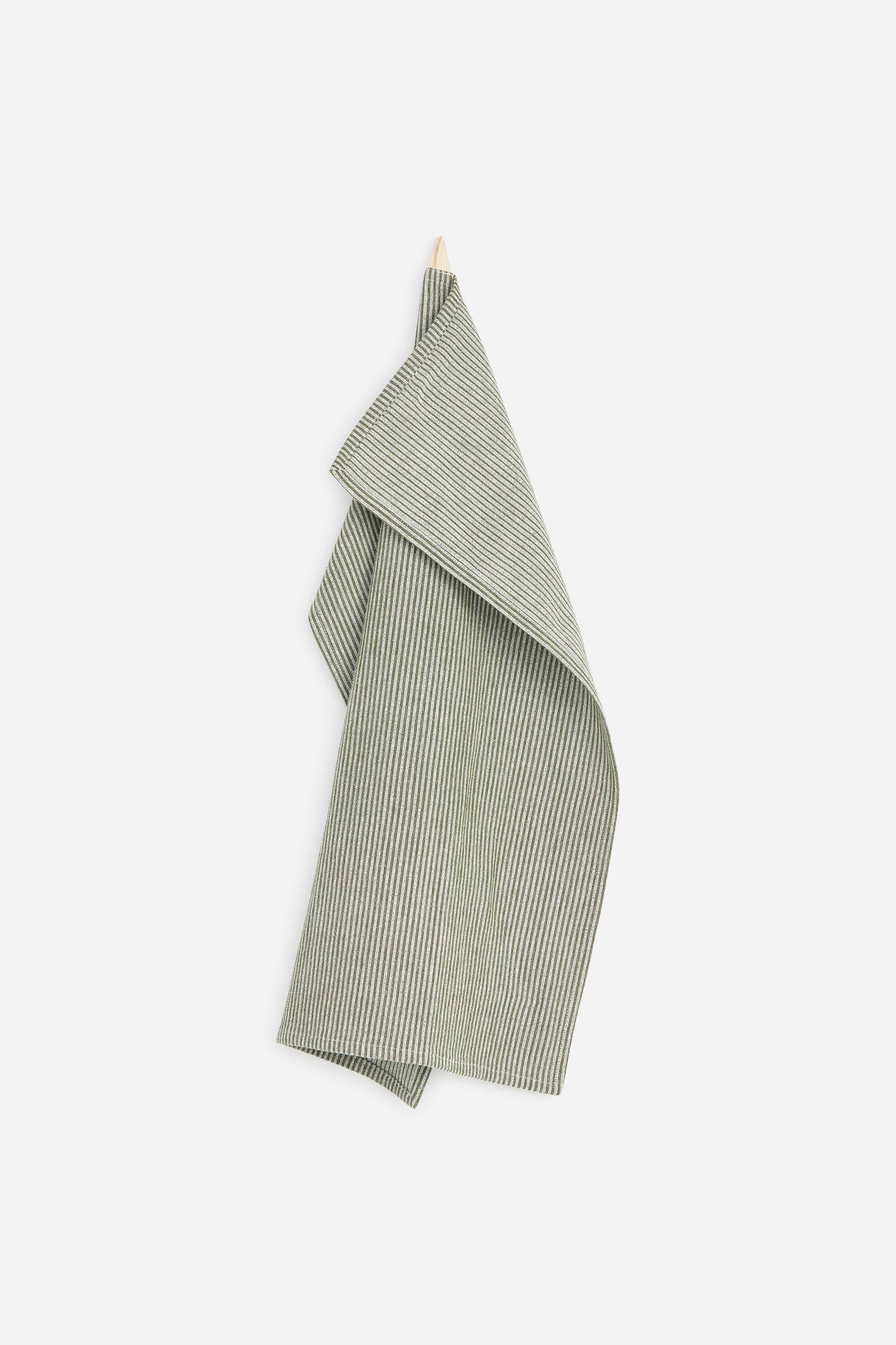 A cotton tea towel featuring a pattern of fine, vertical olive-green and off-white stripes is hanging from a small wooden peg. The towel drapes downward in soft folds, showcasing its woven texture and hemmed borders.