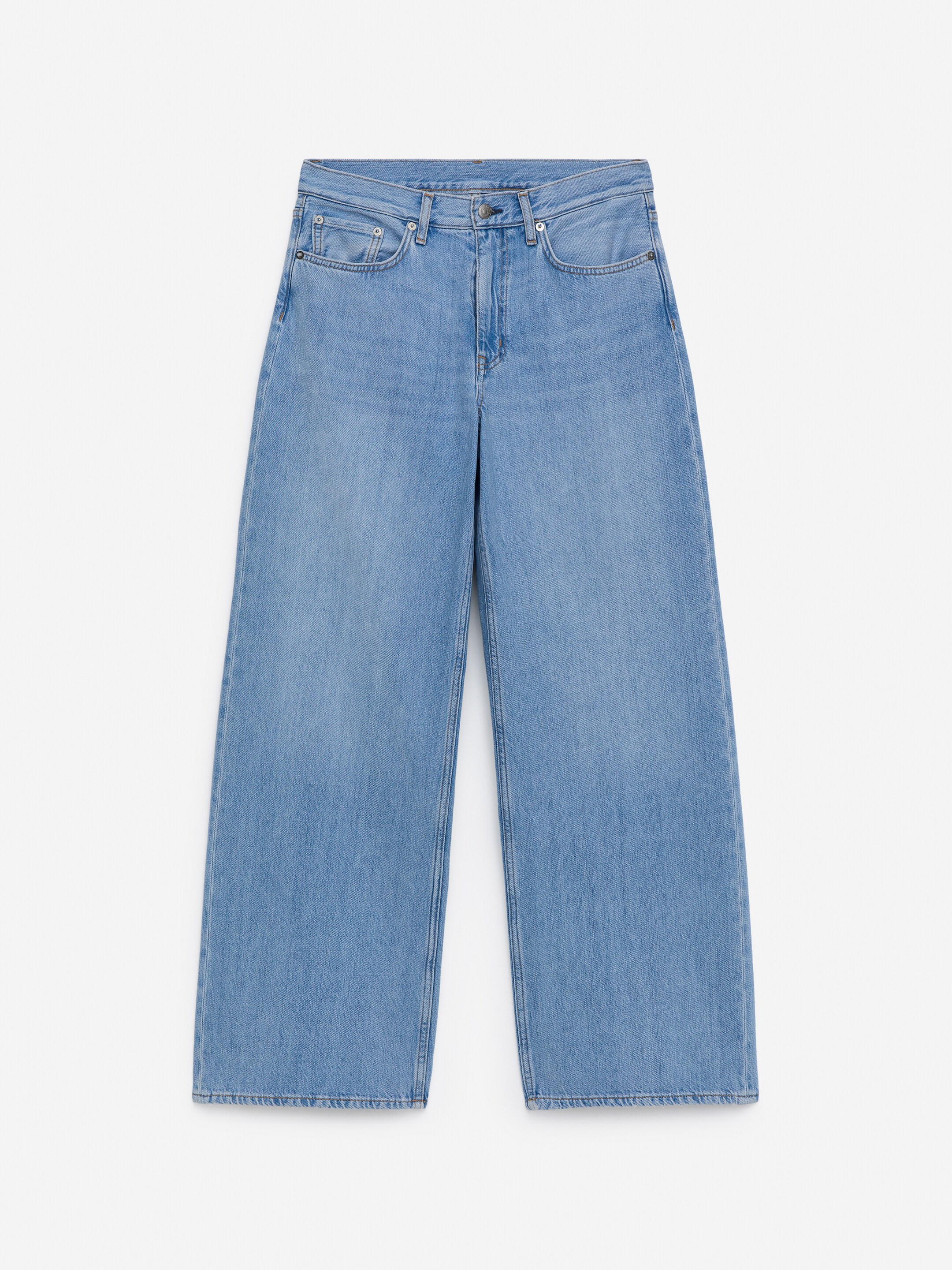 Agrandir l'image: Un pantalon en jean bleu clair est présenté de face, avec une taille basse, une coupe décontractée et des jambes amples. Il comprend une fermeture à glissière et des poches avant classiques.