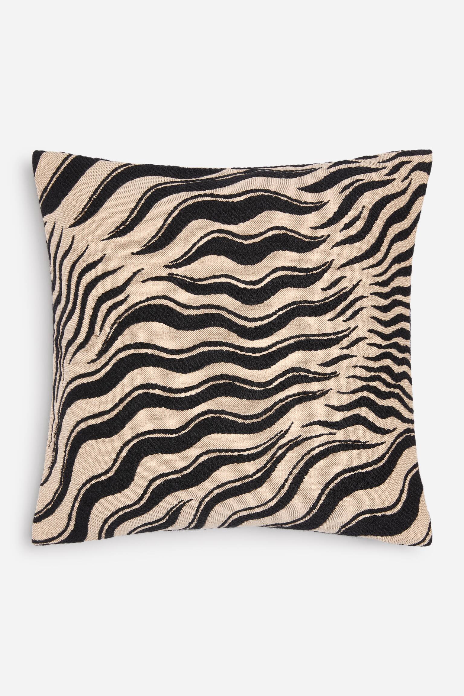 Una federa per cuscino quadrata Ã¨ orientata frontalmente e mostra un motivo zebrato jacquard testurizzato, con strisce nere ondulate su sfondo beige.