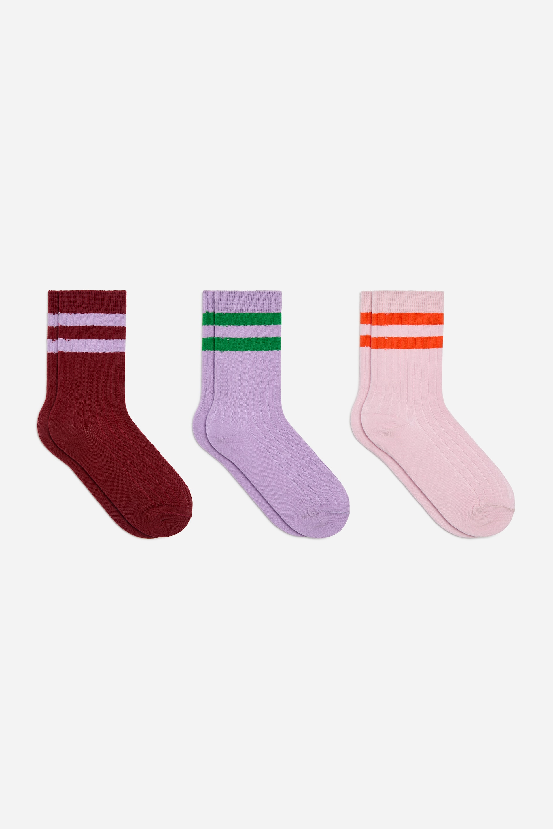 Agrandir l'image: Un ensemble de trois paires de chaussettes côtelées est présenté. Chaque paire arbore deux bandes horizontales sur la tige, avec des coloris comprenant le bordeaux et le violet clair, le lavande et le vert, ainsi que le rose clair et l’orange.