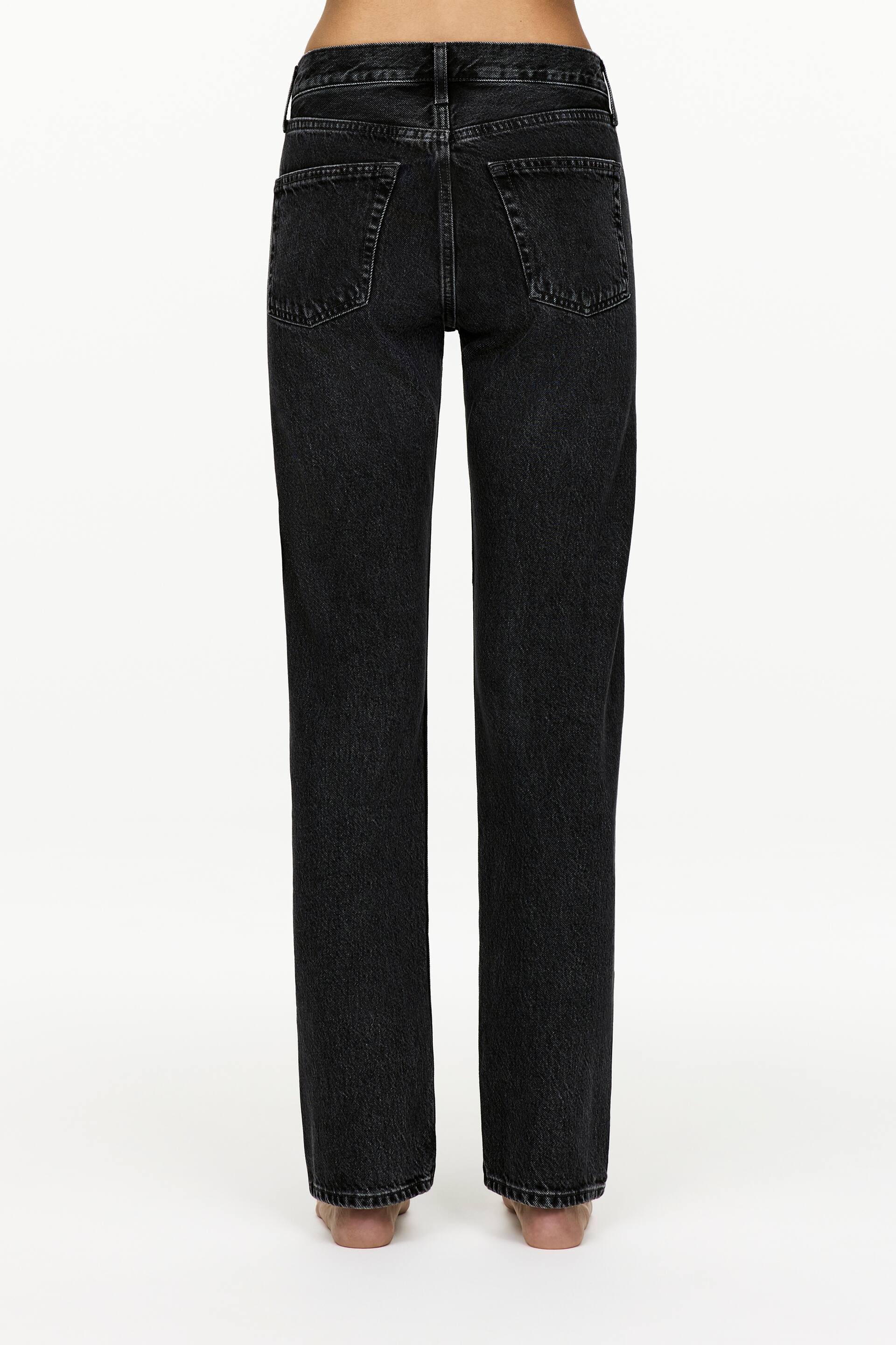 Agrandir l'image: Un jean en denim noir délavé est présenté de dos, avec une coupe droite. Le jean présente deux poches arrière plaquées avec des coutures visibles, et une ceinture standard avec des passants pour ceinture.