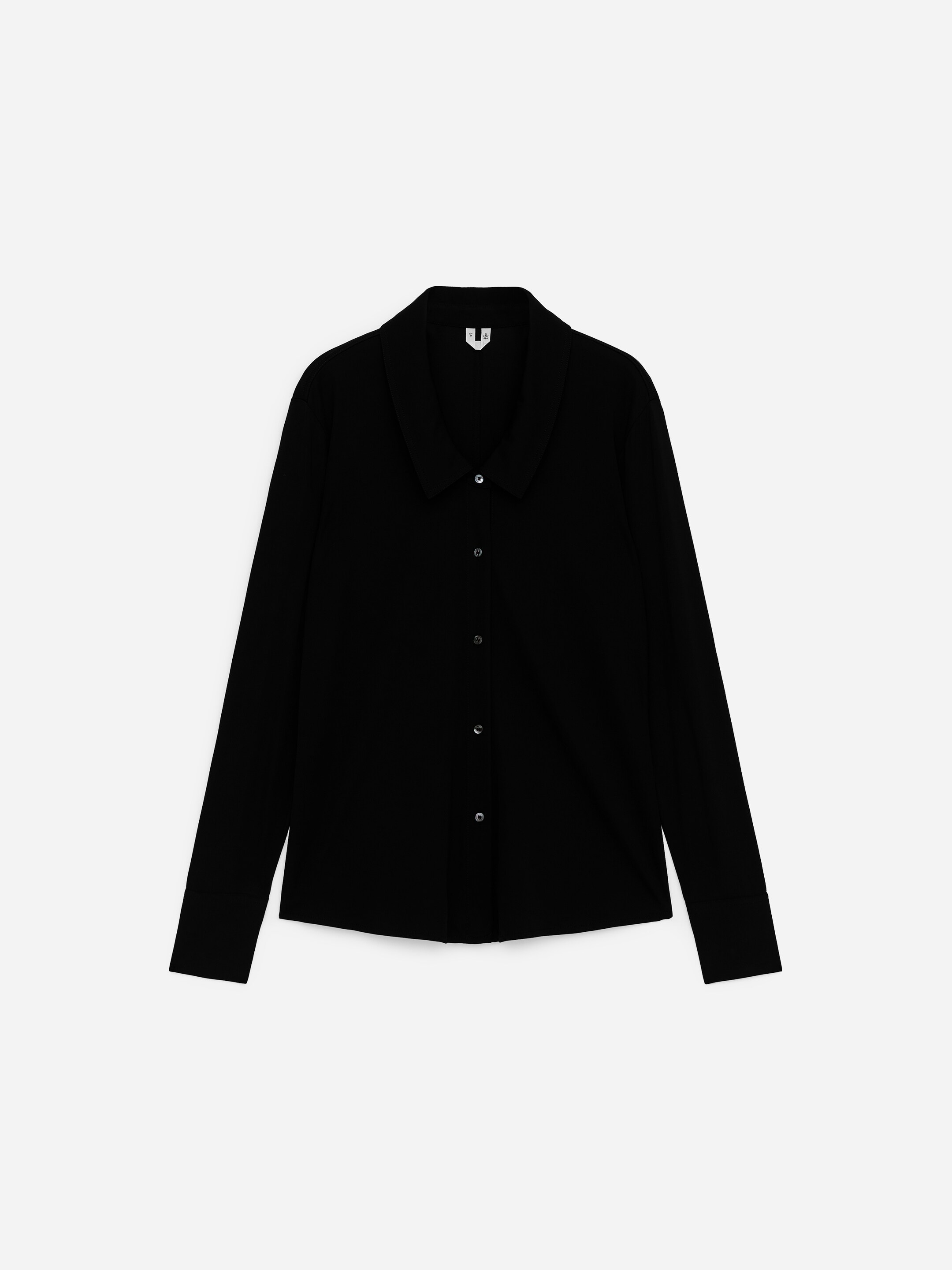 Visualizza immagine più grande: Una camicia nera mostra la parte ANTERIORE, caratterizzata da un colletto classico appuntito e maniche lunghe. Ha un'apertura frontale completamente abbottonata con cinque bottoni rotondi scuri, e una piccola etichetta bianca è visibile sul retro del colletto.