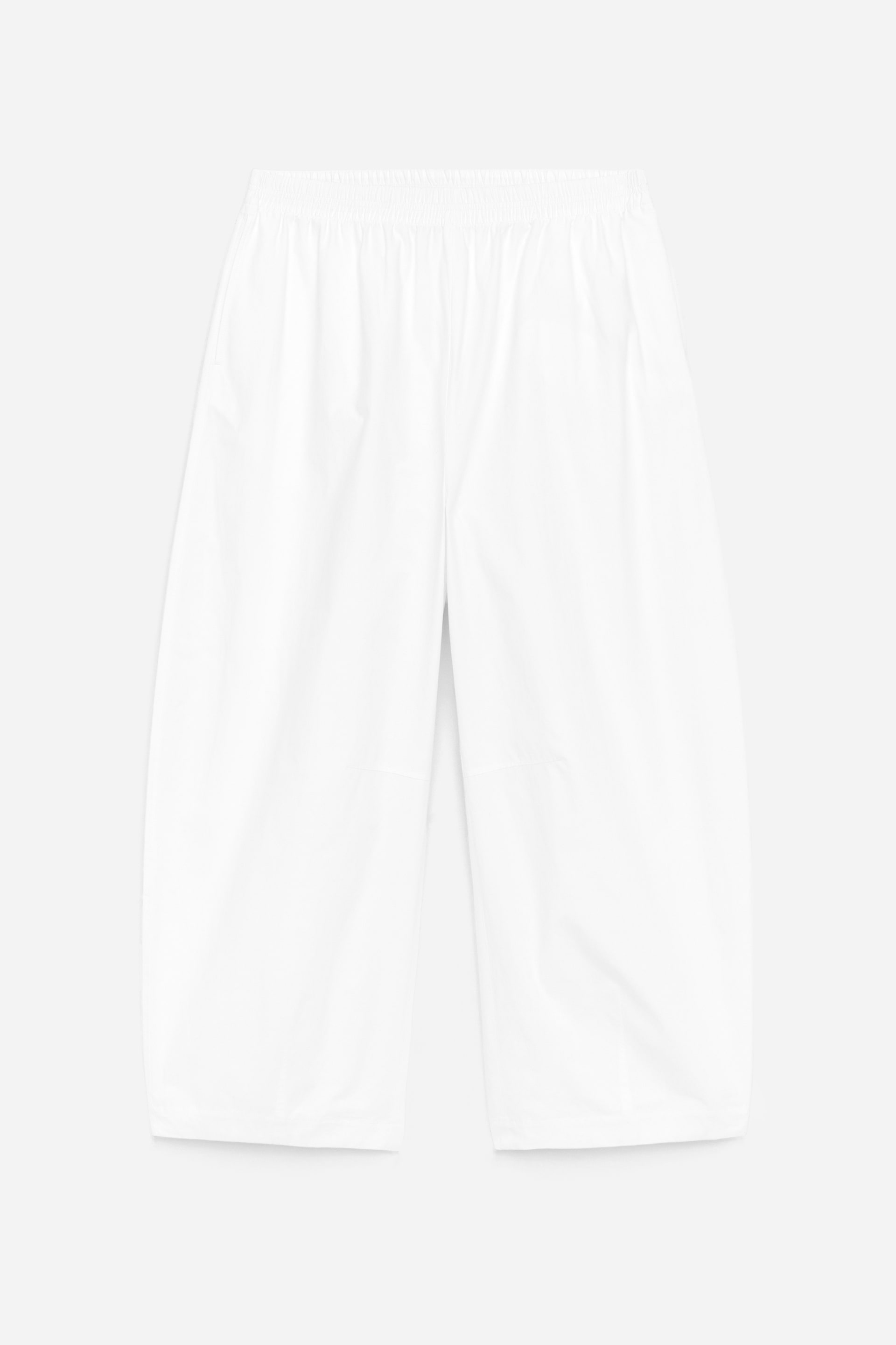 Agrandir l'image: Pantalon blanc à jambes larges vu de face, avec taille élastiquée et poches latérales. Les jambes amples et courbées présentent des détails subtils de pinces.