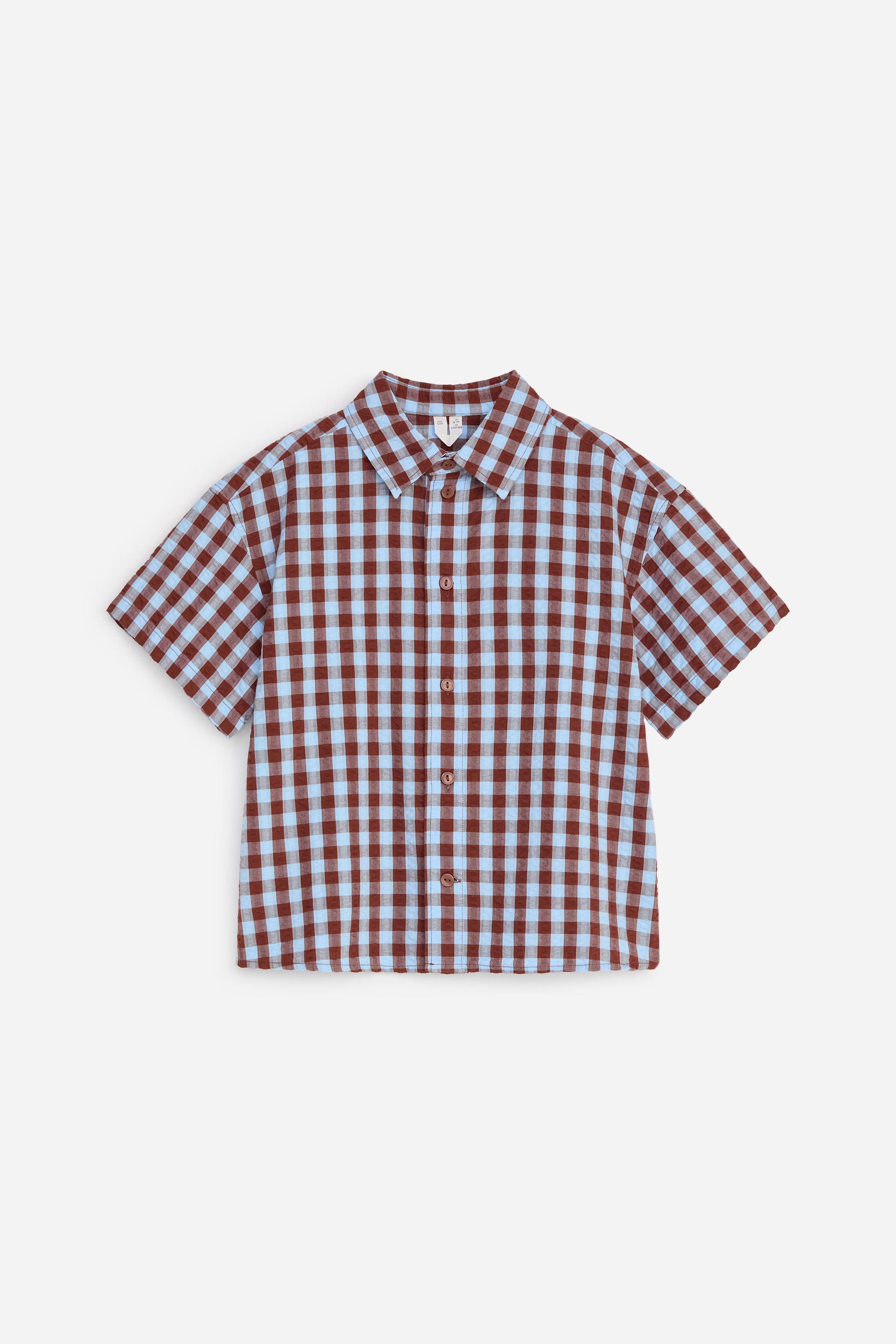 Grotere afbeelding bekijken: Een hemd met korte mouwen toont een bruin en lichtblauw gingham patroon, met de voorkant naar voren gericht. Het heeft een puntige kraag, een volledige knoopsluiting aan de voorkant met bruine knopen en een enkele borstzak aan de linkerkant.