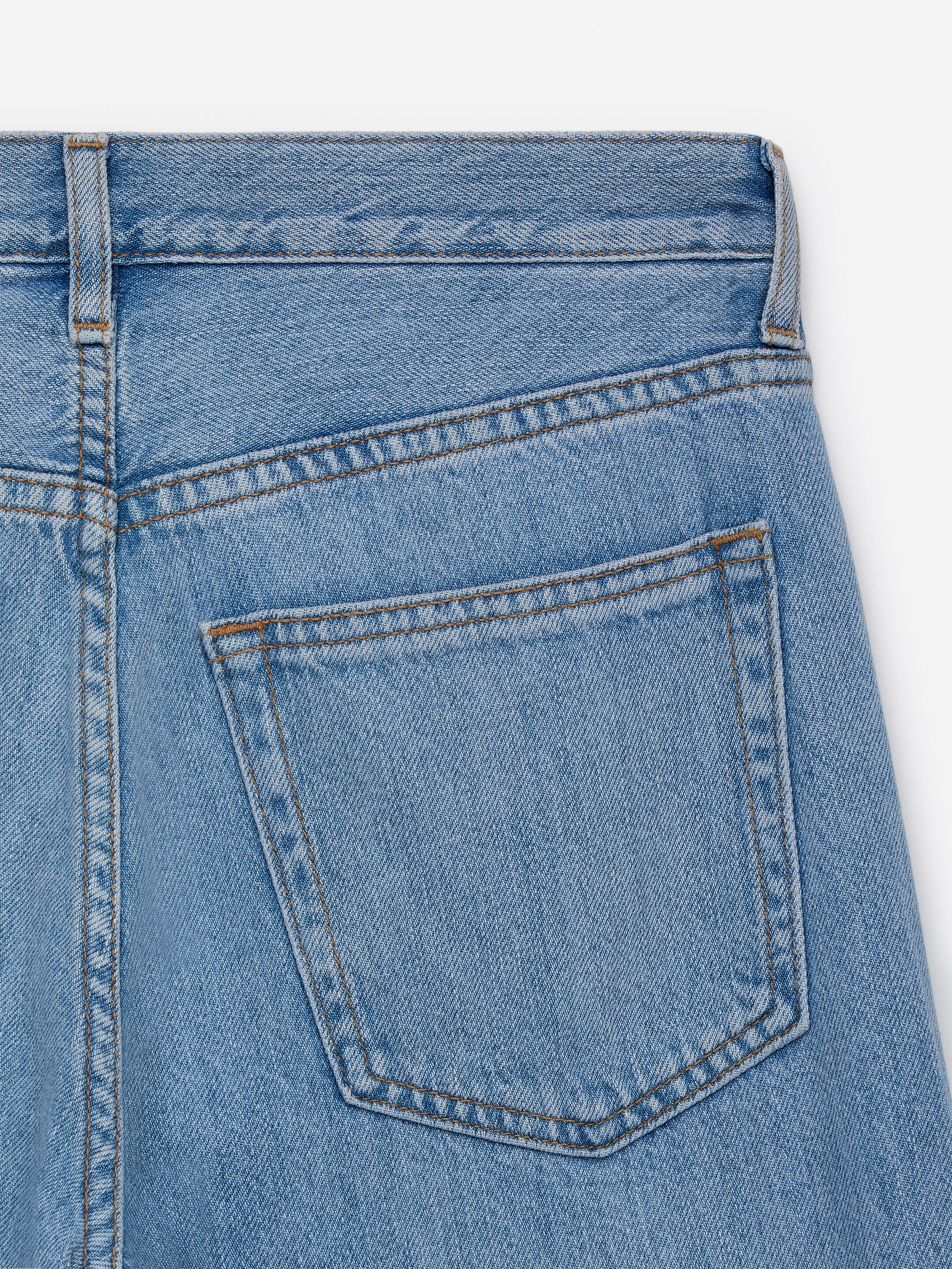 Agrandir l'image: L'arrière du jean en denim bleu clair présente une ceinture avec des passants pour ceinture et une poche plaquée, le tout détaillé avec des coutures contrastantes marron.