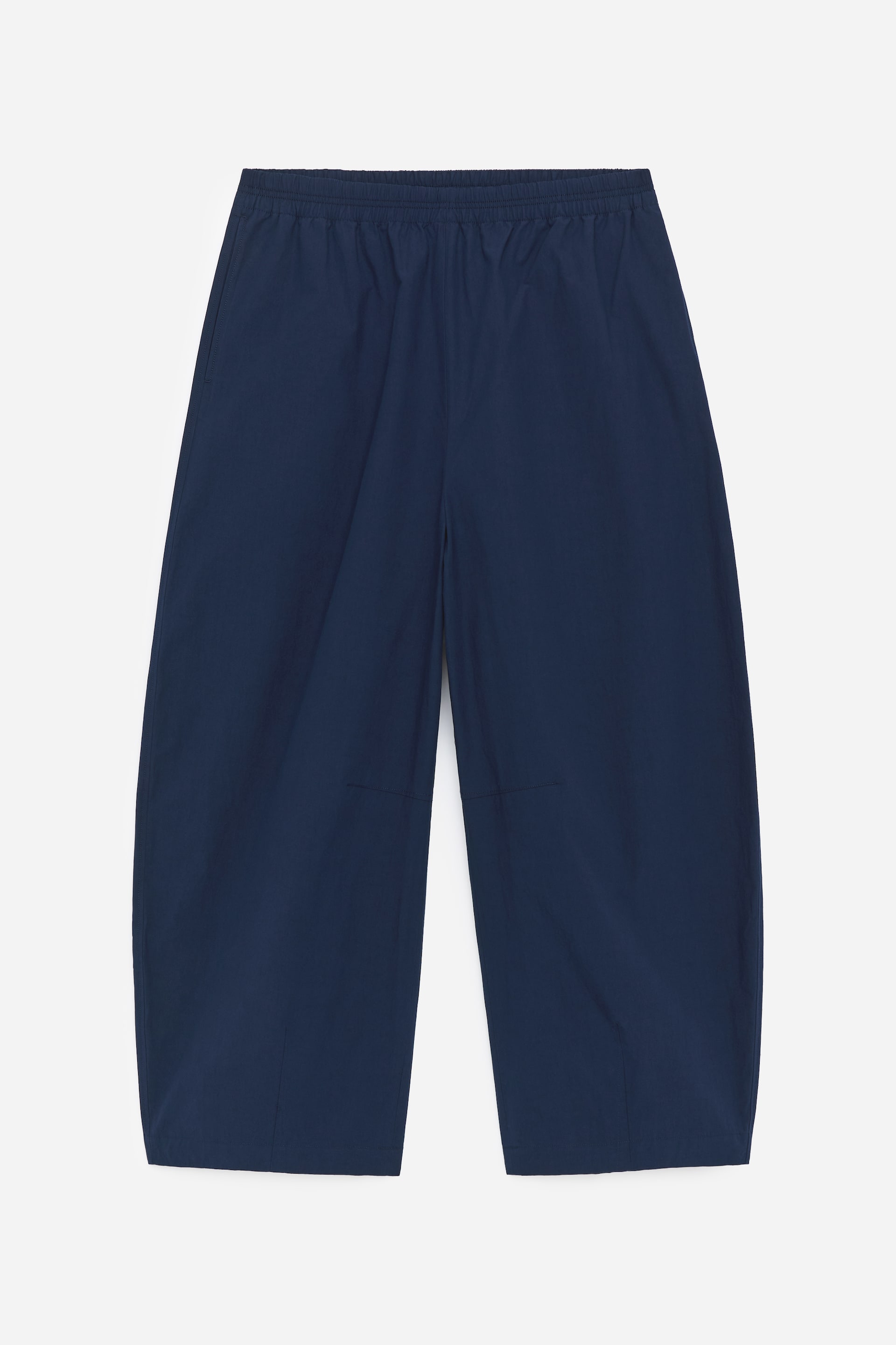Ver imagen más grande: Pantalones azul oscuro de pierna ancha presentados desde el FRENTE, con cintura elástica, bolsillos laterales y detalles de costuras visibles en la parte delantera de las piernas.