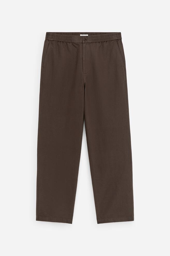 Dunkelbraune Hose aus Leinenmischung, frontal präsentiert, mit elastischem Bund sowie Knopf- und Reißverschluss, schrägen Vordertaschen und regulärer Passform. - 1