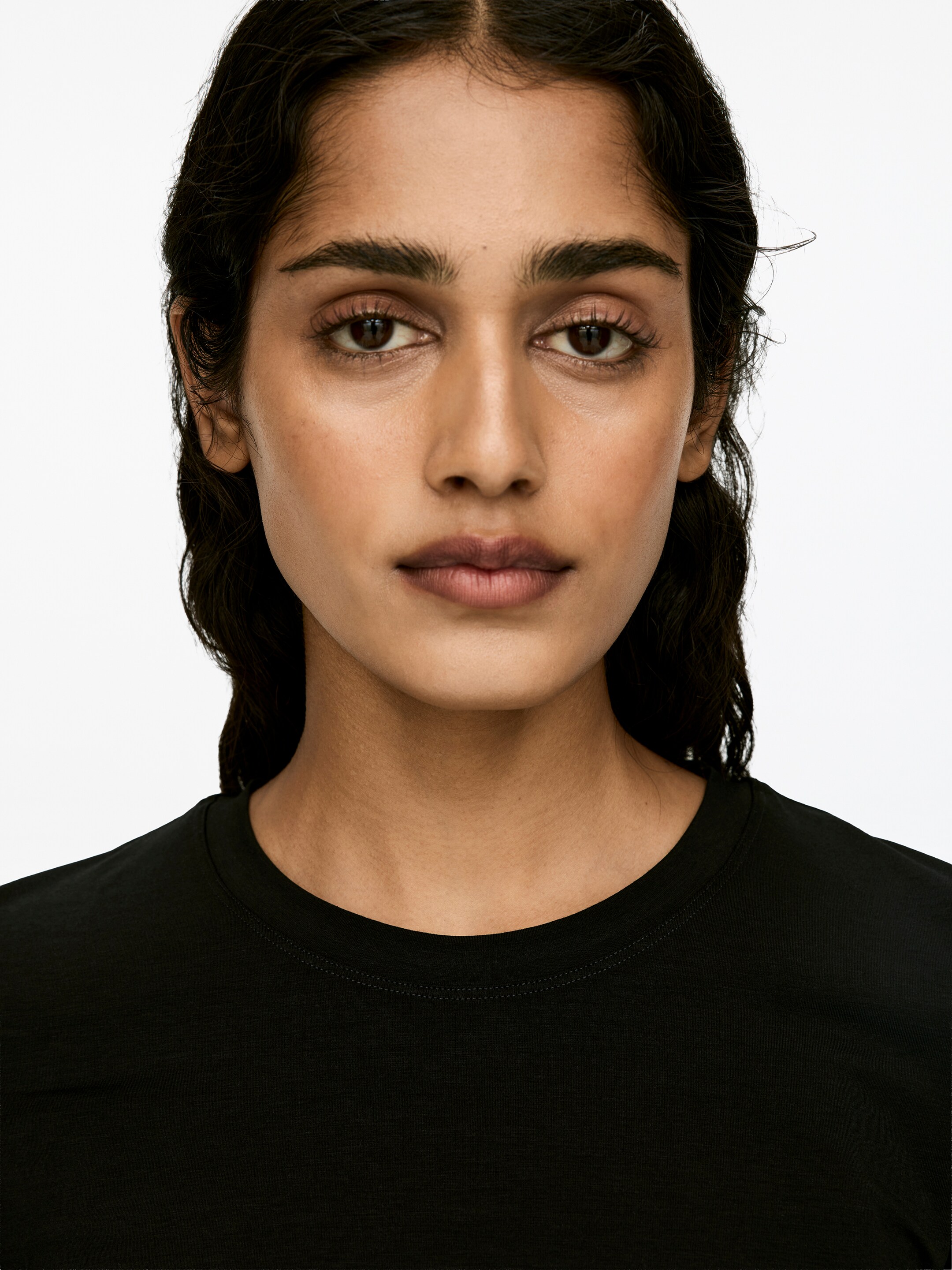 View larger image: A black long-sleeved top with a round neck is being worn by the model.