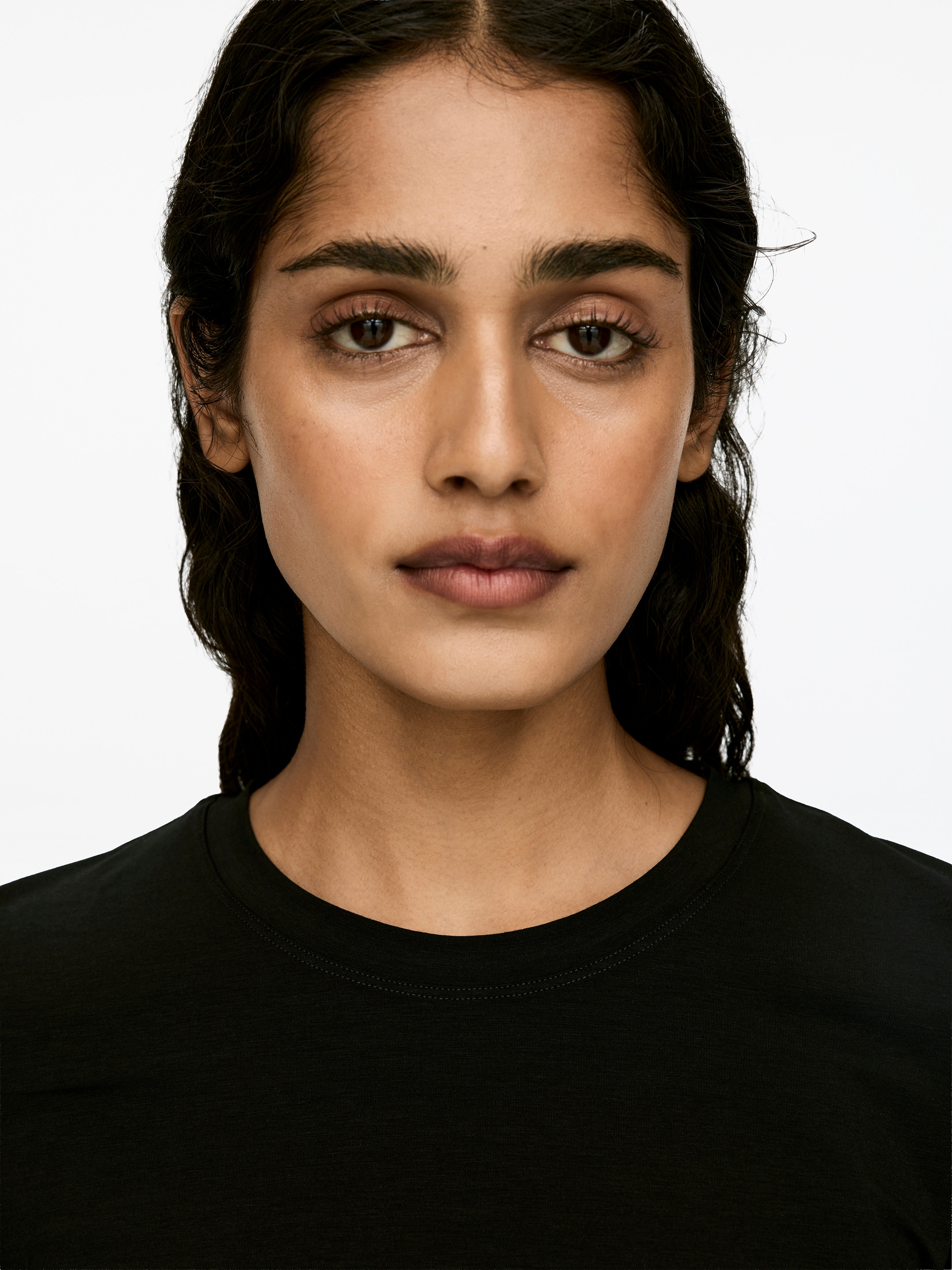 Se større billede: Modellen har en sort langærmet top med rund hals på.