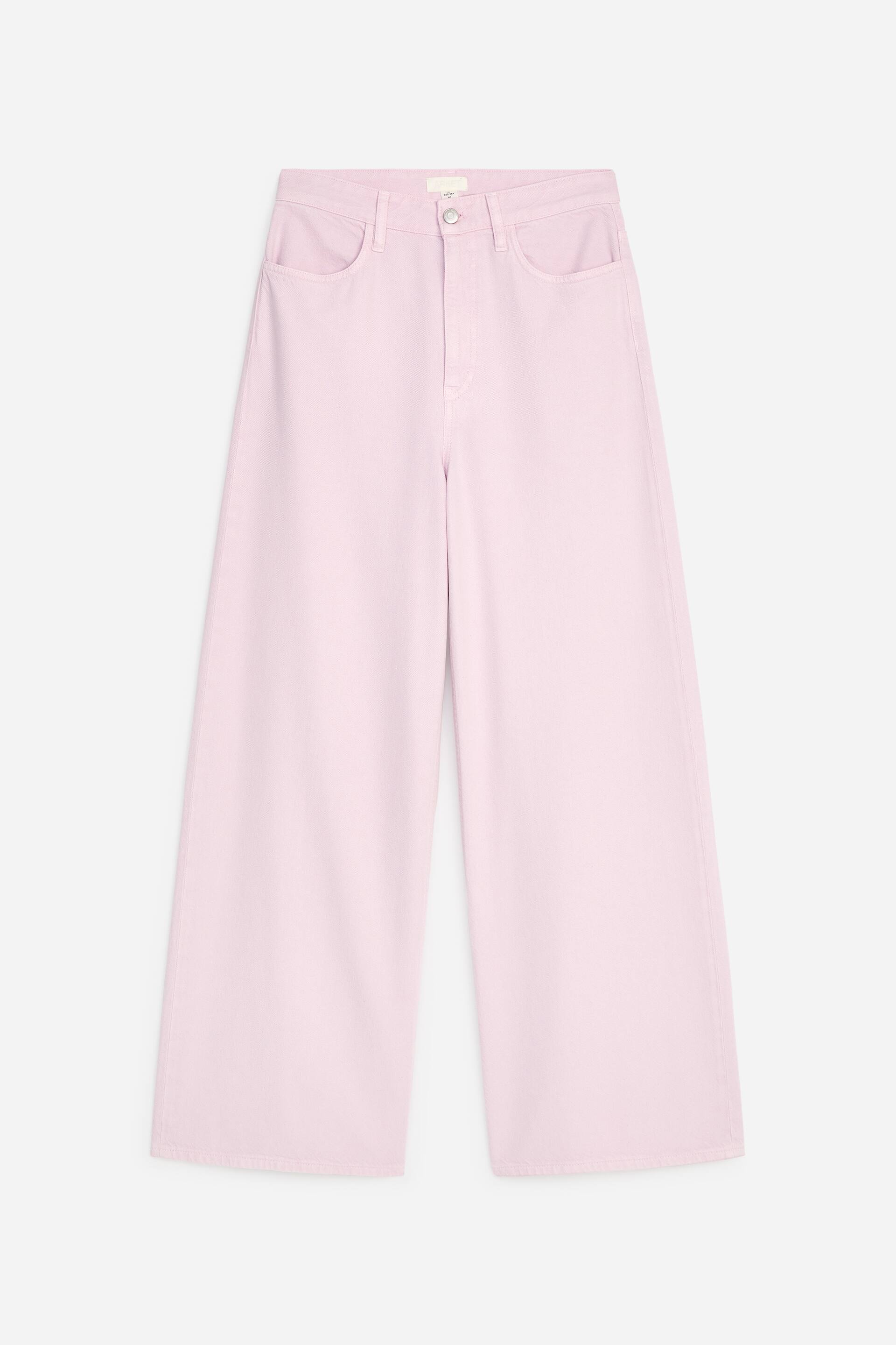 Agrandir l'image: Un pantalon rose pâle à jambes larges est présenté de face. Il présente une taille haute avec une fermeture à bouton unique et une braguette zippée, et deux poches en biais sont visibles sur les hanches à l'avant.