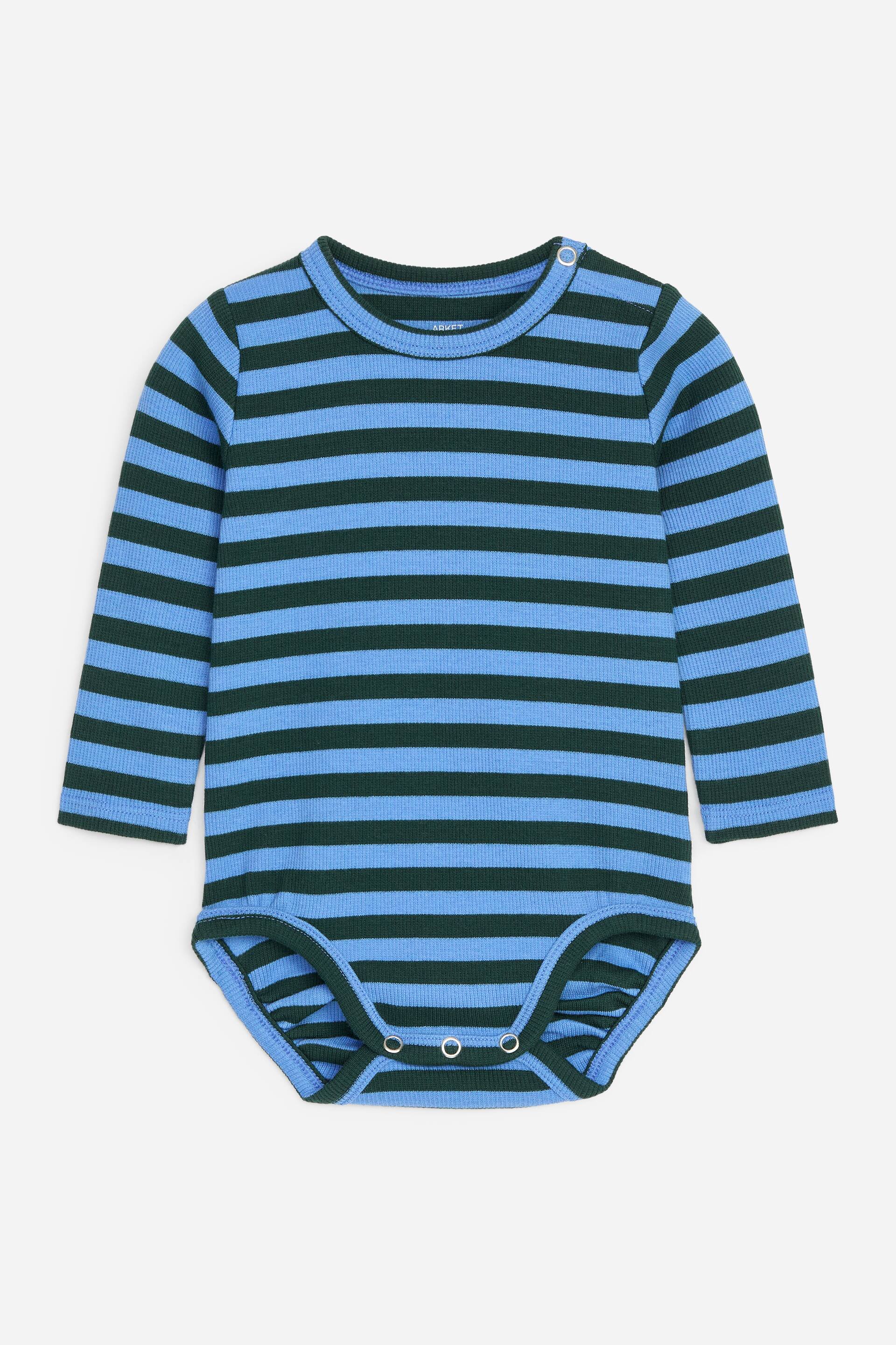 Visa större bild: En babyromper visar blå och mörkgröna horisontella ränder, presenterad platt framifrån. Den har en ribbstickad textur, långa ärmar, rund hals med tryckknappar på vänster axel och extra tryckknappar i grenen.