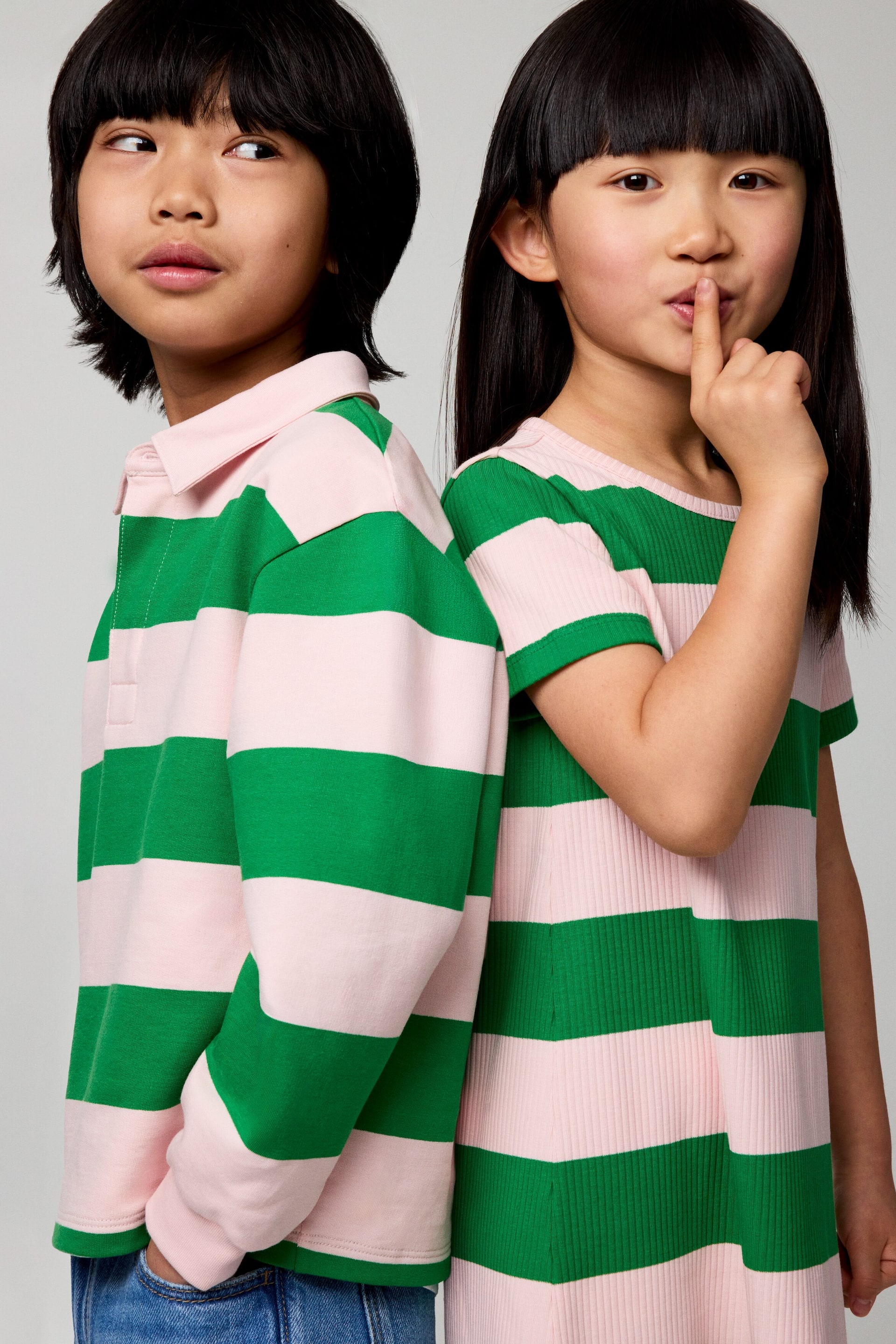 Zobrazit větší obrázek: Dlouhý rukáv polokošile se zelenými a světle růžovými vodorovnými pruhy, s růžovým límečkem a zapínáním na knoflíky. Krátký rukáv žebrovaný pletený top se stejnými zelenými a světle růžovými vodorovnými pruhy a kulatým výstřihem.