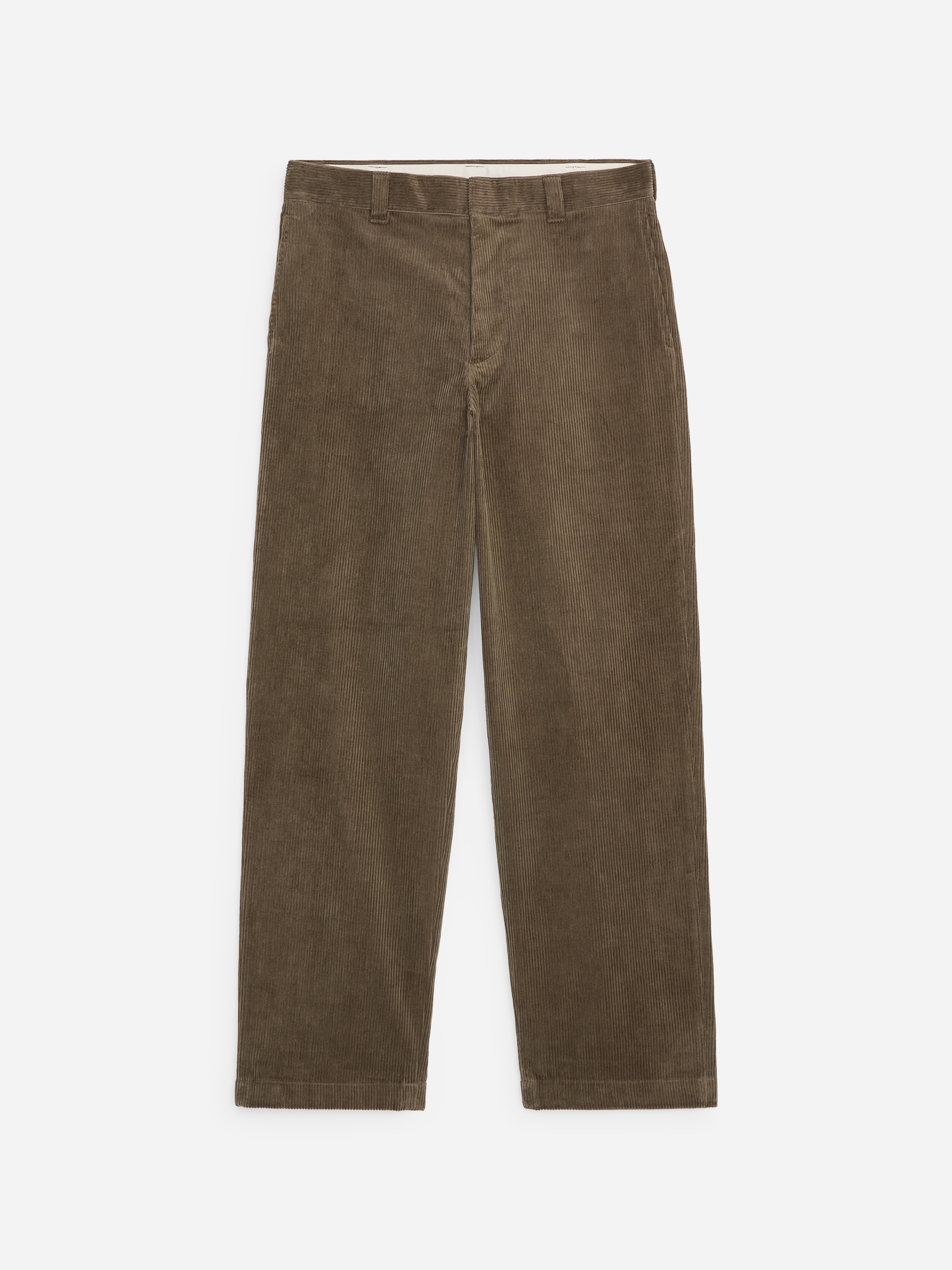 Brown corduroy trousers in a relaxed, wide-leg fit are being worn by the model. The trousers are styled with a navy double-breasted jacket, a dark blue crew-neck sweater, and black leather shoes.