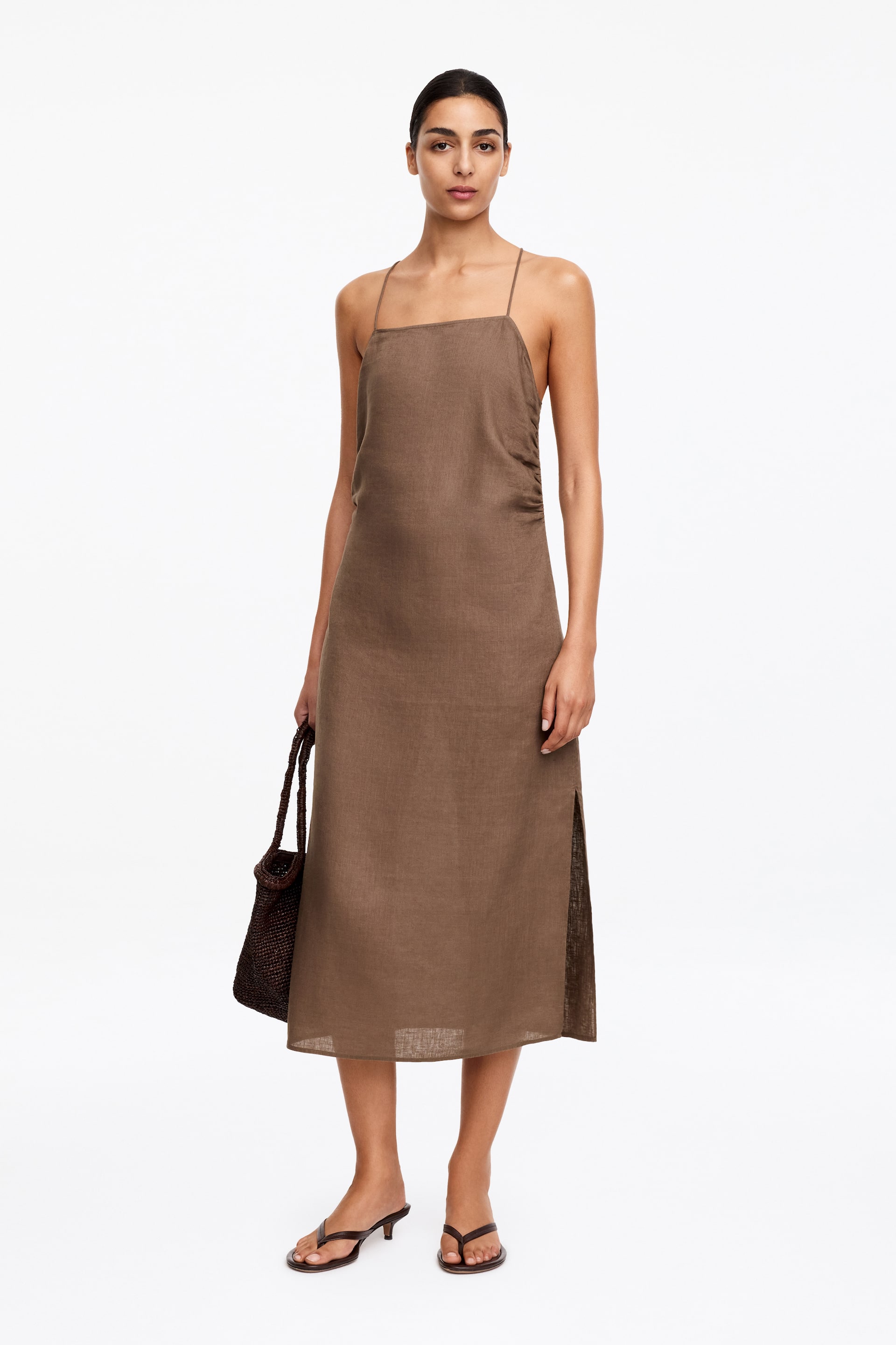 Agrandir l'image: La robe midi marron présente un décolleté carré avec de fines bretelles spaghetti et un froncement latéral sur le corsage. Elle offre une coupe décontractée avec des fentes latérales sur la jupe et est confectionnée dans un tissu texturé.