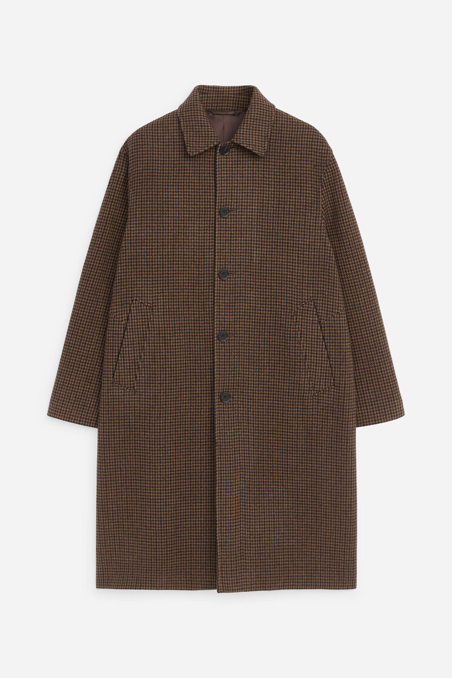 Un cappotto lungo monopetto con motivo pied-de-poule marrone e nero Ã¨ mostrato frontalmente, con un classico colletto a punta e chiusura a cinque bottoni. Il cappotto presenta maniche lunghe e due tasche a filetto oblique laterali.