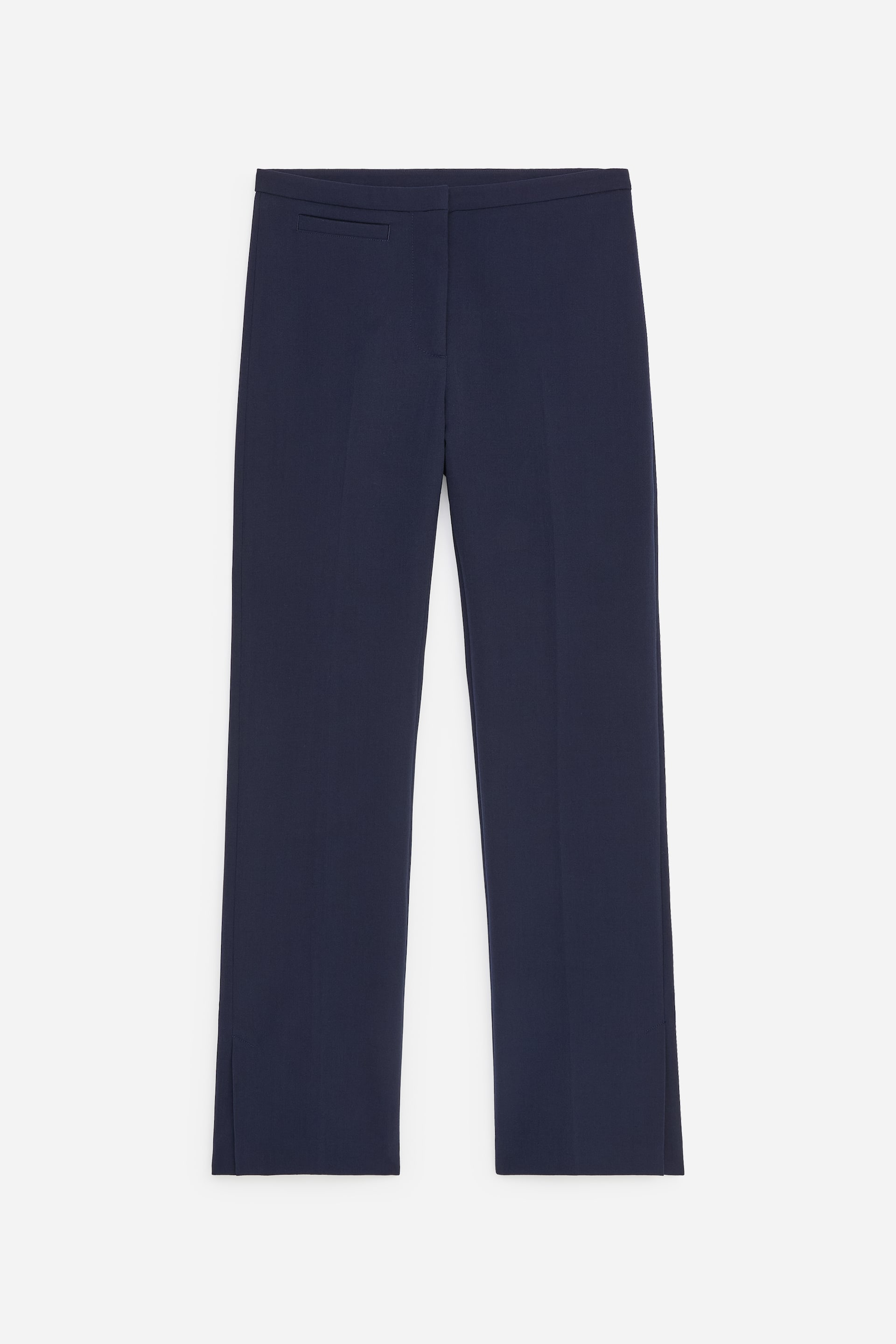 Agrandir l'image: Ce pantalon tailleur bleu marine est présenté de face, avec une silhouette ajustée, une taille mi-haute et une seule poche passepoilée sur le haut du côté gauche. Les jambes droites affichent de subtiles plis centraux et de petites fentes latérales aux ourlets extérieurs.