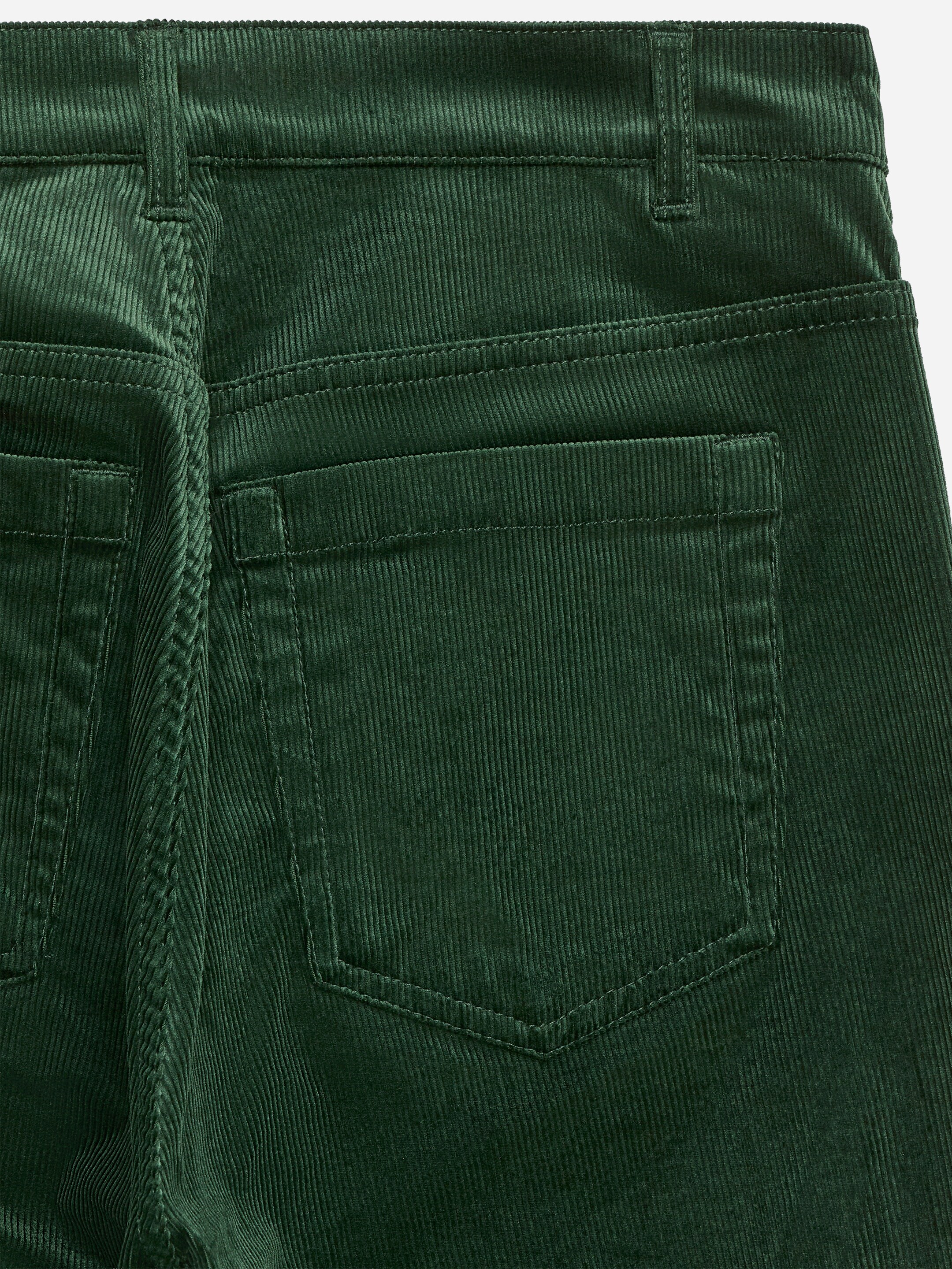 Ver imagen más grande: Se muestra la parte trasera de unos pantalones de pana verde oscuro, que presenta una cintura con trabillas para el cinturón, un canesú cosido y dos bolsillos de parche.