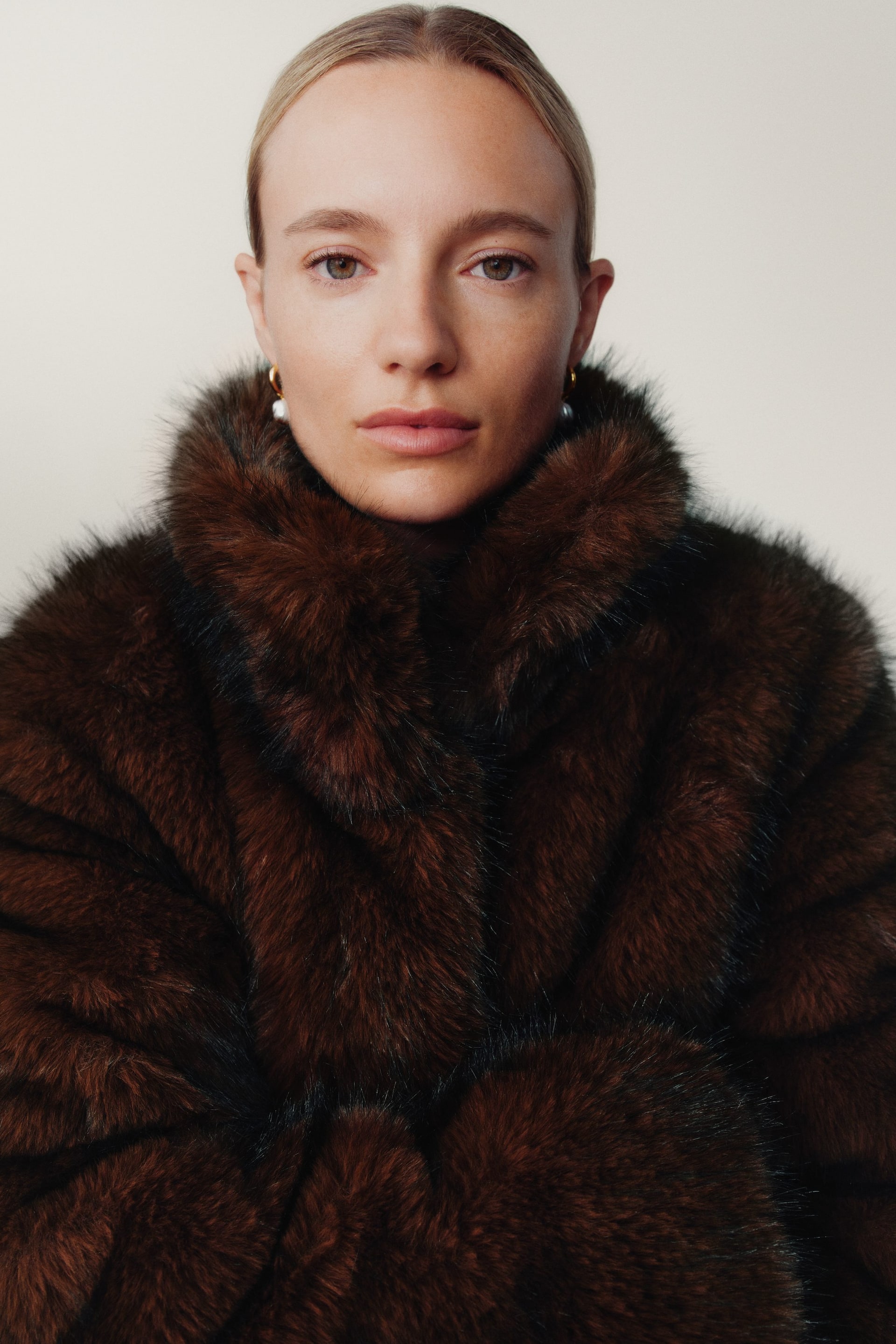 View larger image: A rich brown fur coat is being worn, featuring a dense, plush texture and a prominent, full collar that is framing the neck and shoulders.