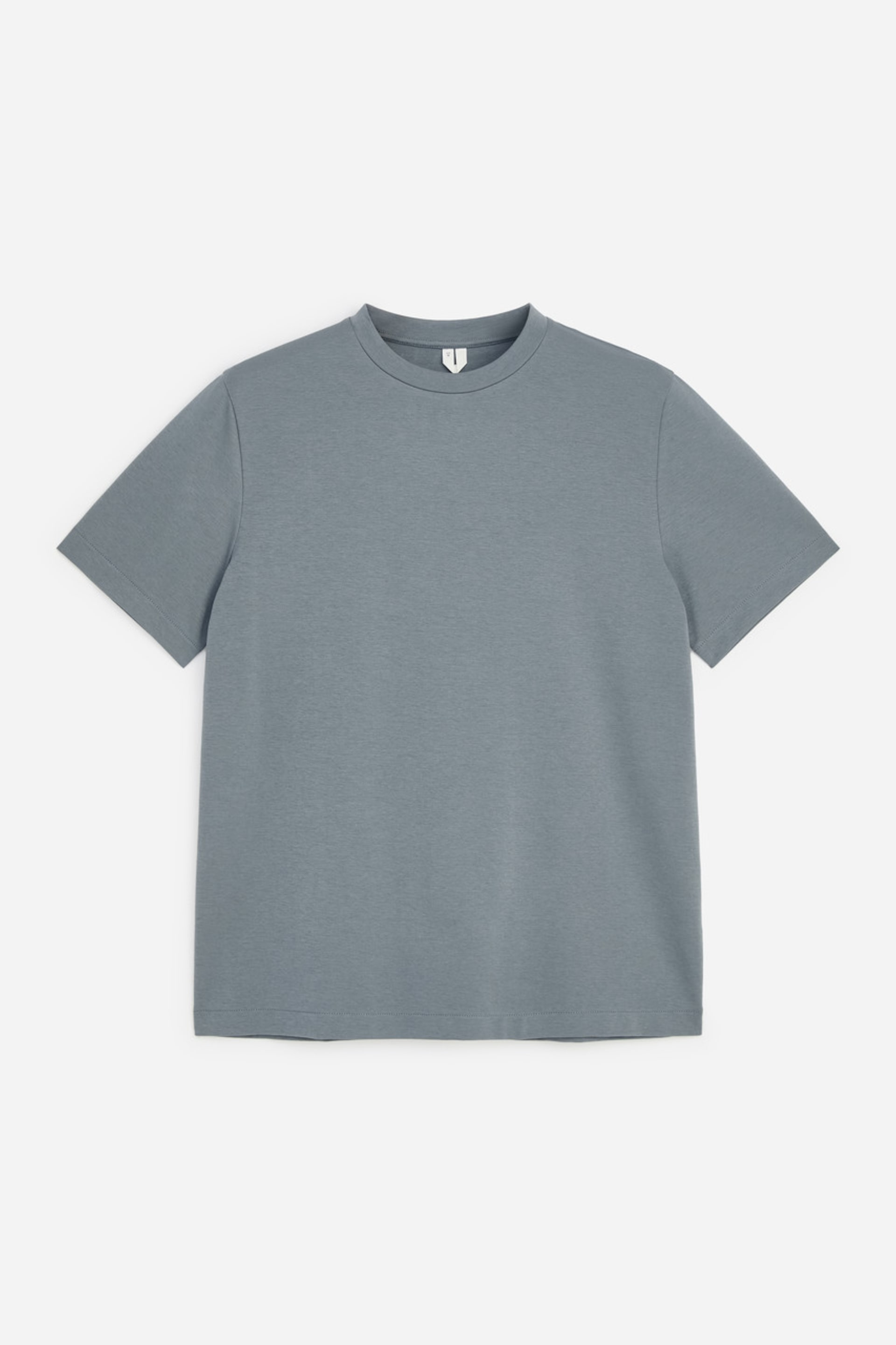 Ver imagem maior: Uma t-shirt de gola redonda e manga curta, numa cor azul-cinzento suave, está estendida na horizontal e virada para a frente. A peça apresenta um corte regular, com gola redonda canelada e uma textura lisa em jersey interlock.