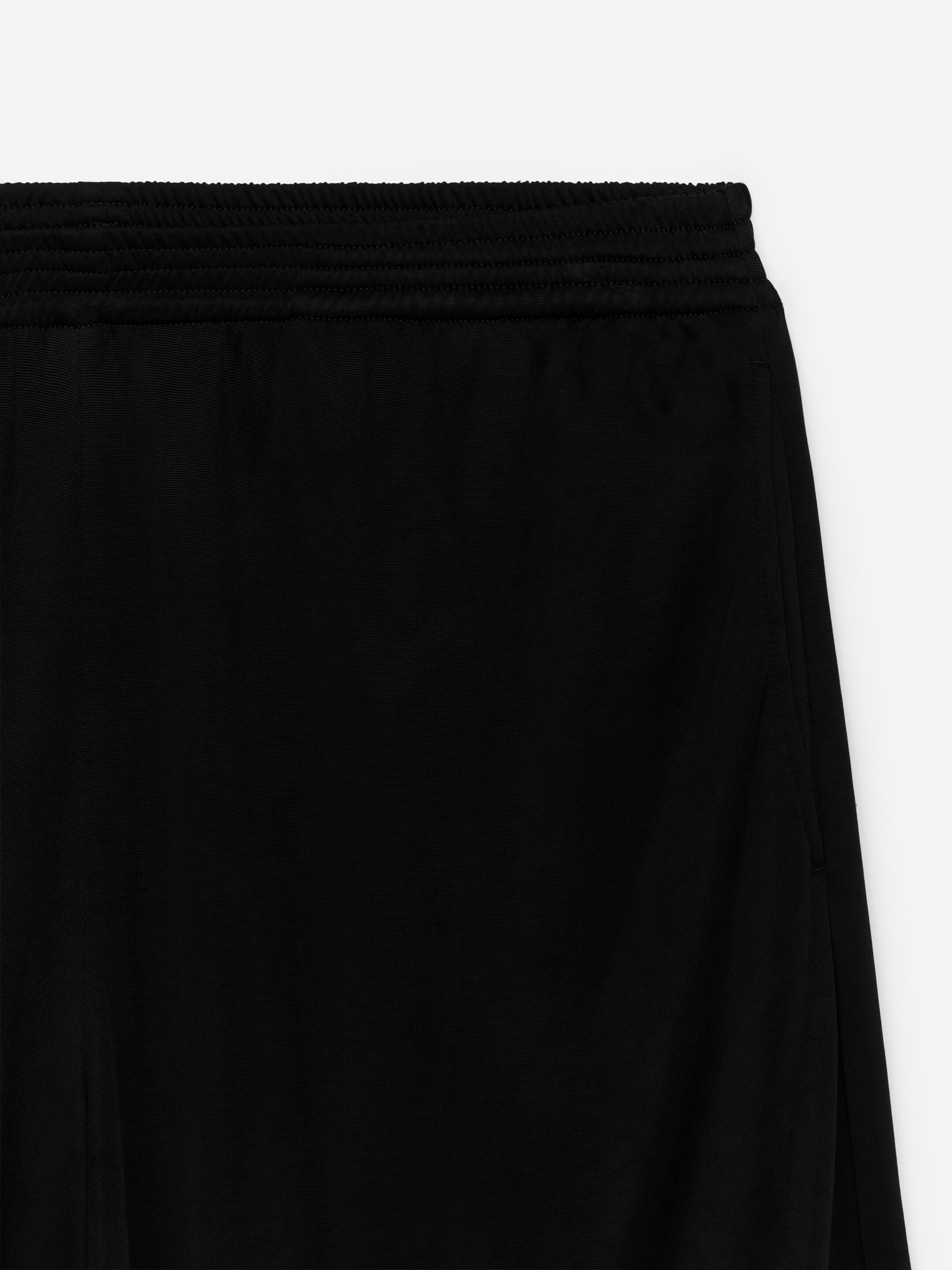 Visa större bild: Framsidan av svarta ballongbyxor visas. De har en rynkad, elastisk midja med horisontella sömlinjer och sidofickor markerade av vertikala sömmar.