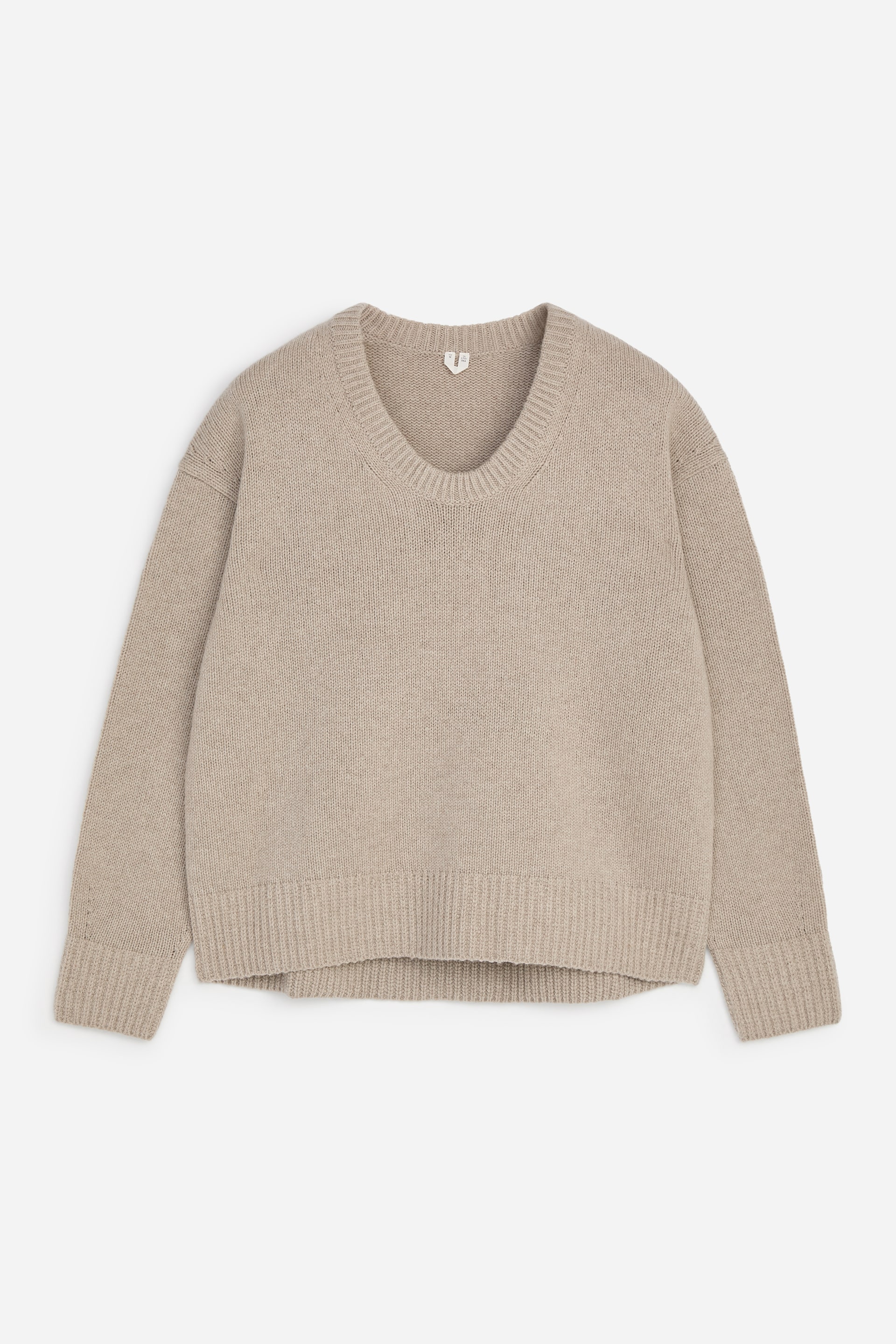 Visualizza immagine più grande: Un maglione beige è mostrato frontalmente, caratterizzato da un ampio scollo a V, maniche lunghe con polsini a coste e un orlo a coste.