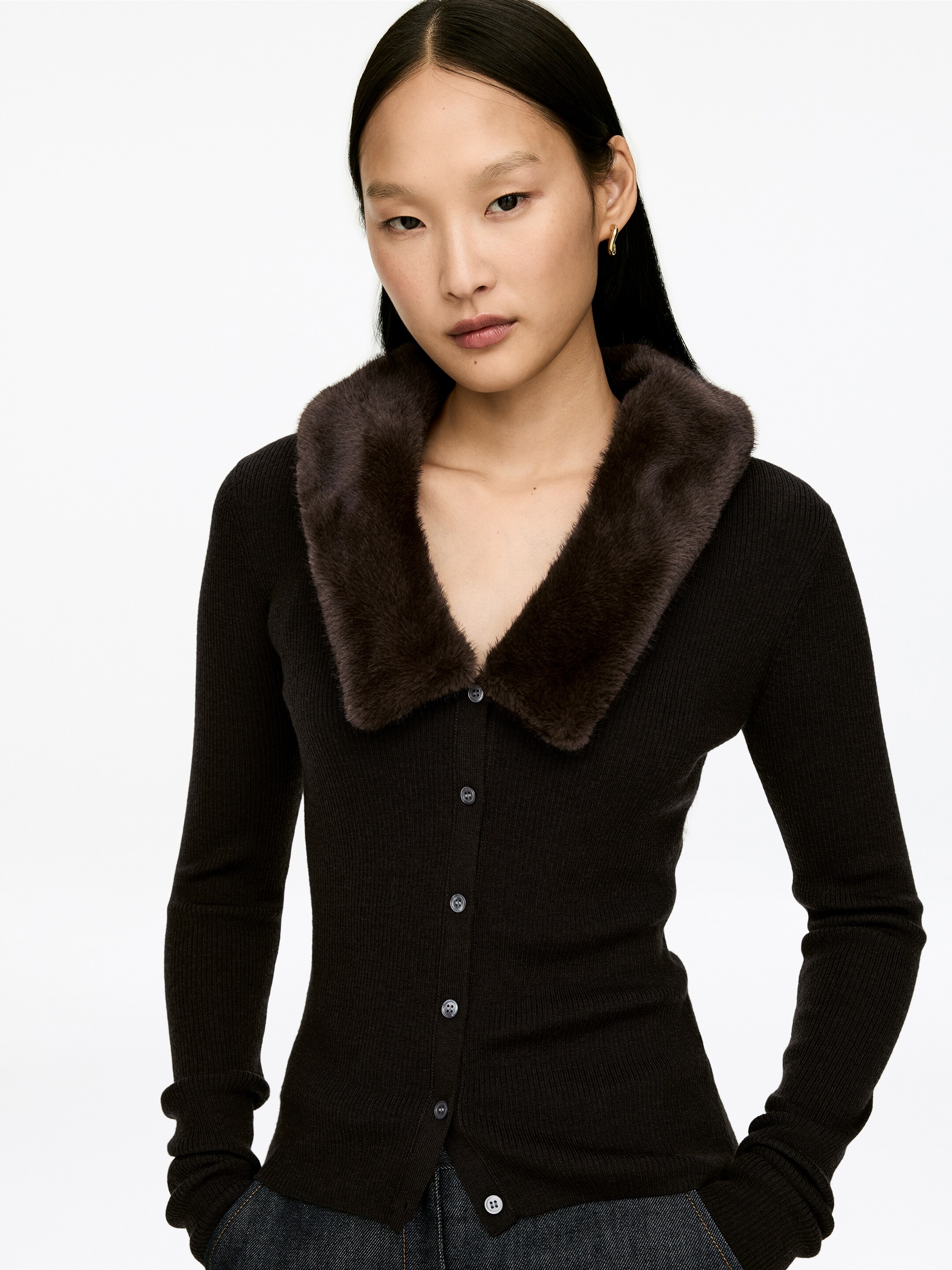 Agrandir l'image: Un cardigan côtelé brun foncé se présente, avec un col en fausse fourrure brun foncé pelucheux. Il est conçu avec une fermeture à boutons sur le devant et des manches longues, mettant en valeur des boutons de couleur claire.