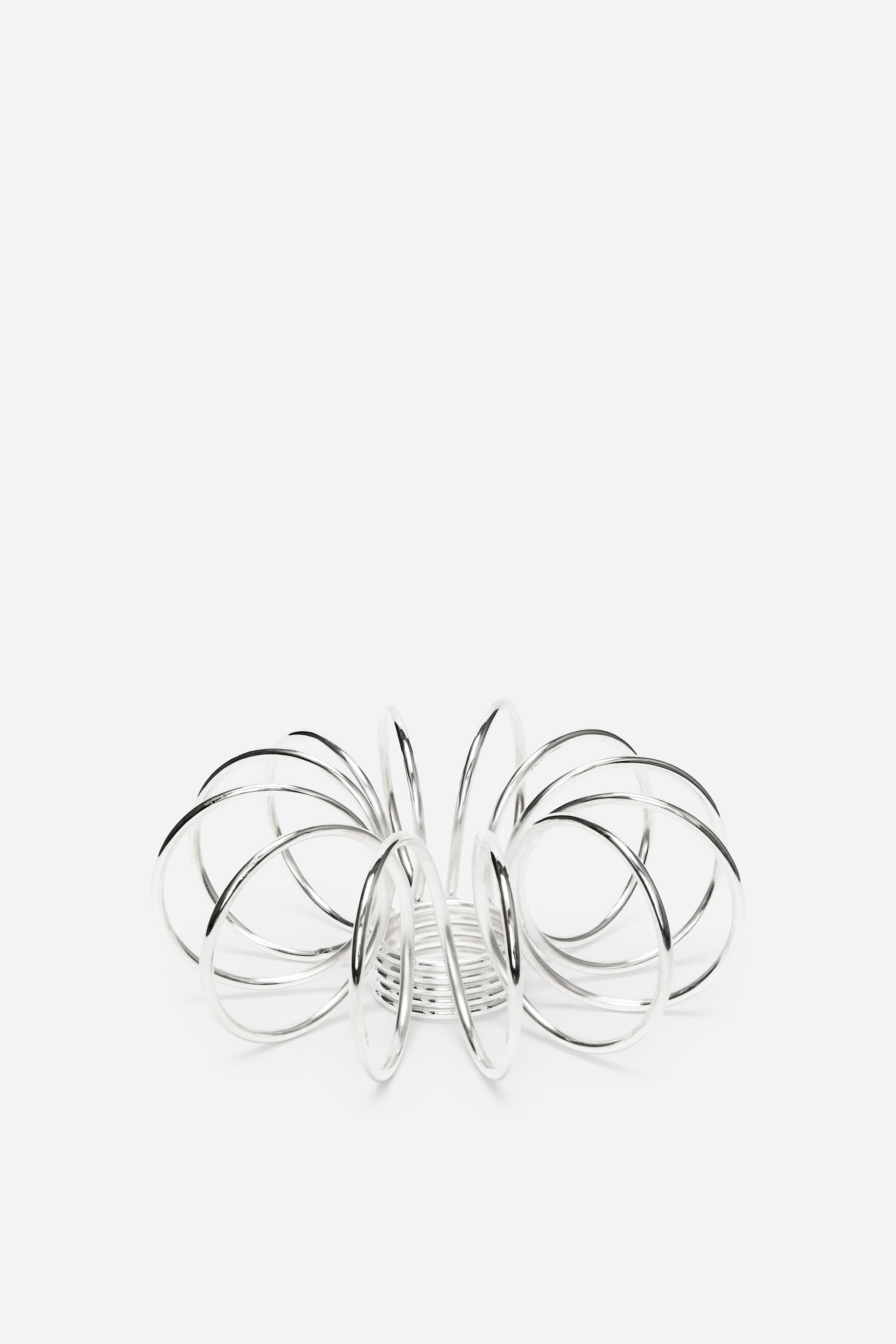 Zobraziť väčší obrázok: Strieborná kovová štruktúra sa vyznačuje prepojenými, leštenými krúžkami, ktoré tvoria vyžarujúci, špirálovitý dizajn, rozširujúci sa smerom von z centrálnej základne.