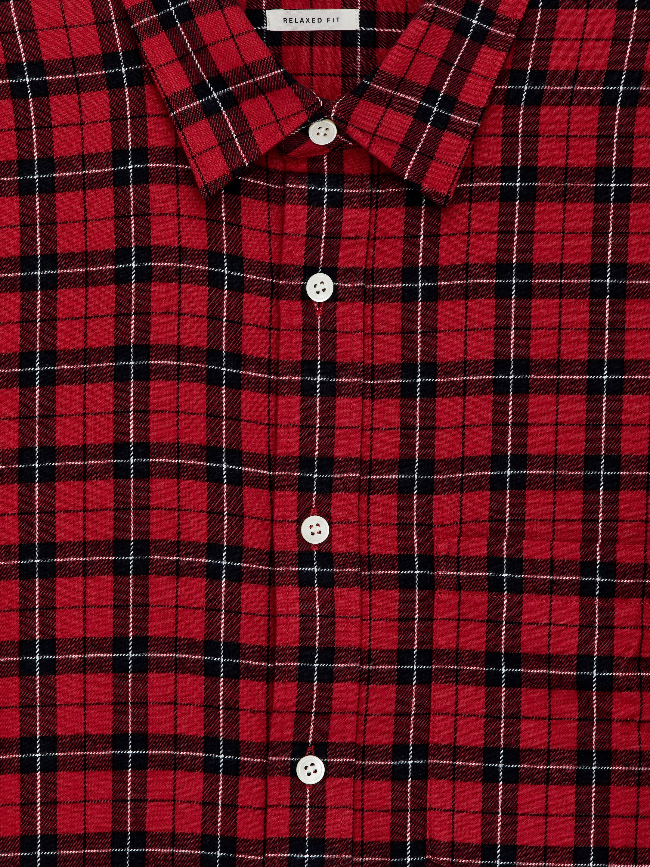 Visualizza immagine più grande: Una camicia di flanella di cotone a quadri rossi, neri e bianchi è esposta dal davanti. Presenta una tasca singola sul petto, bottoni in madreperla e un'etichetta 'RELAXED FIT' visibile sul colletto.