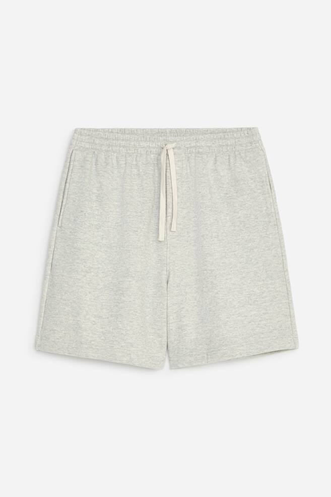 Ein Paar hellgrau melierte Sweatshorts ist von vorne zu sehen und verfÃ¼gt Ã¼ber einen elastischen Bund mit einem cremefarbenen Kordelzug. Die Shorts zeigen eine lÃ¤ssige Passform mit seitlichen Nahttaschen und geradem Saum. - 1