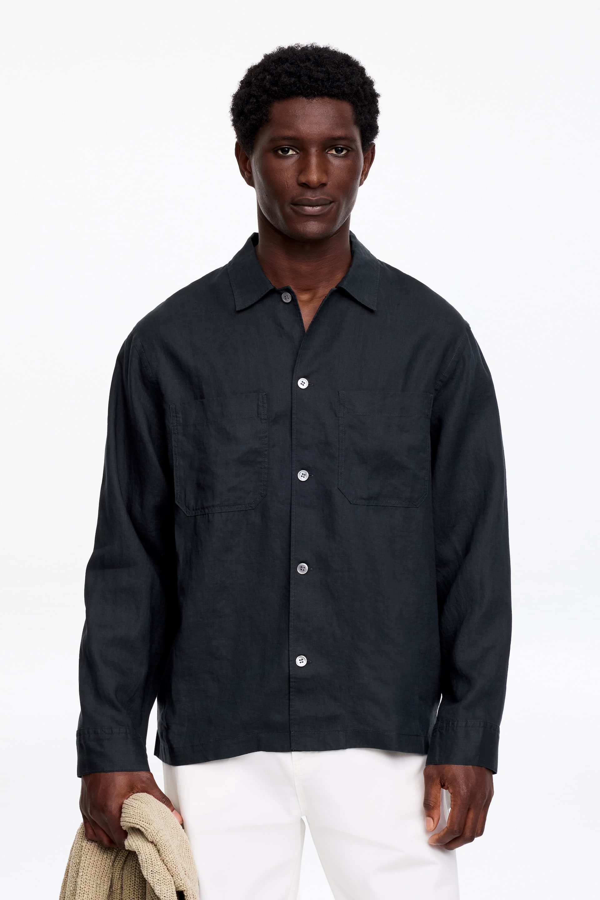 Visualizza l'immagine ingrandita: Una camicia nera a maniche lunghe in lino, con due tasche sul petto, bottoni bianchi sul davanti e una vestibilità ampia, è indossata dalla modella.