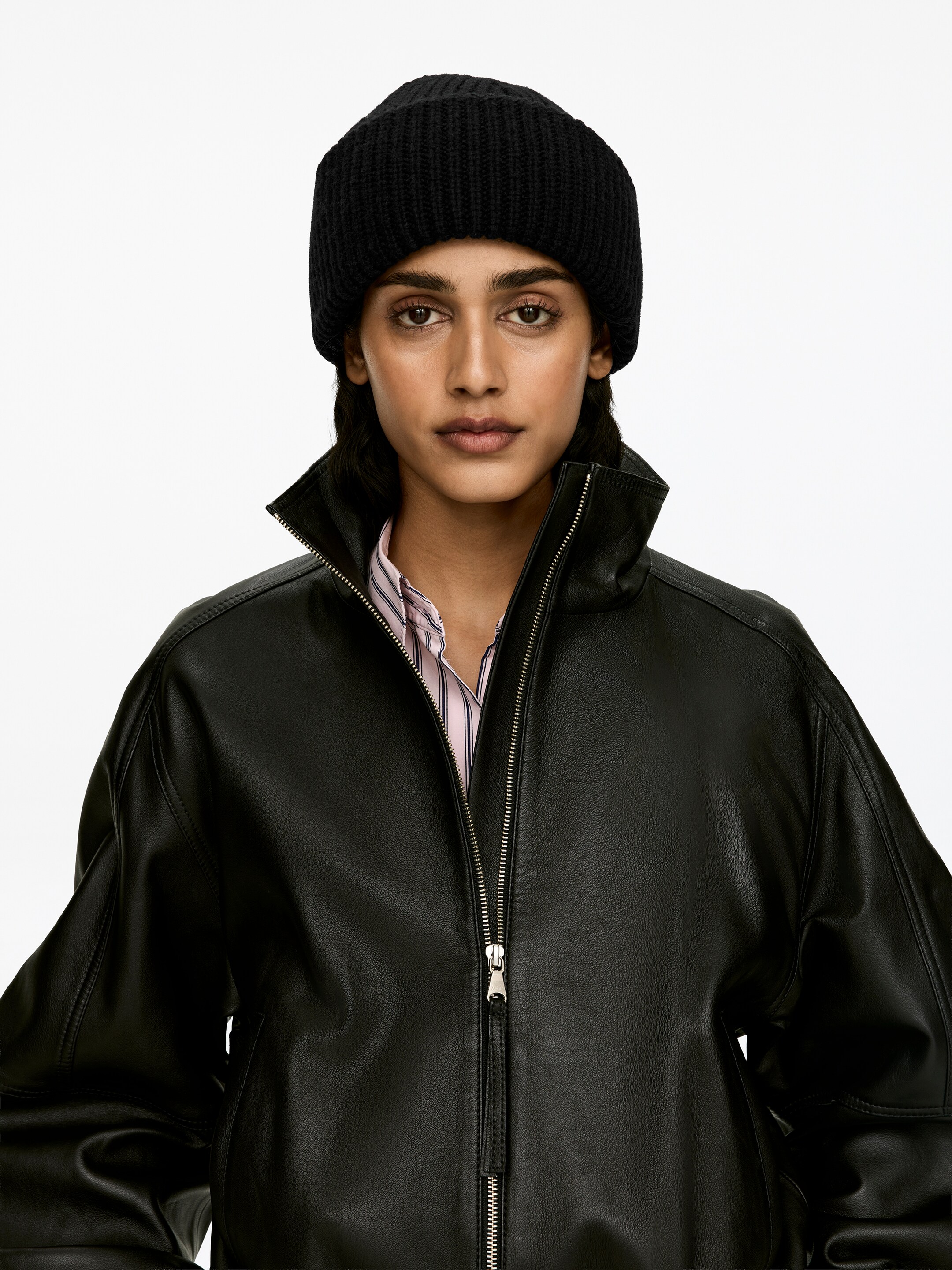 Agrandir l'image: Un bonnet en laine noir à double rabat, tricoté en point de demi-cardigan, est porté par le mannequin.