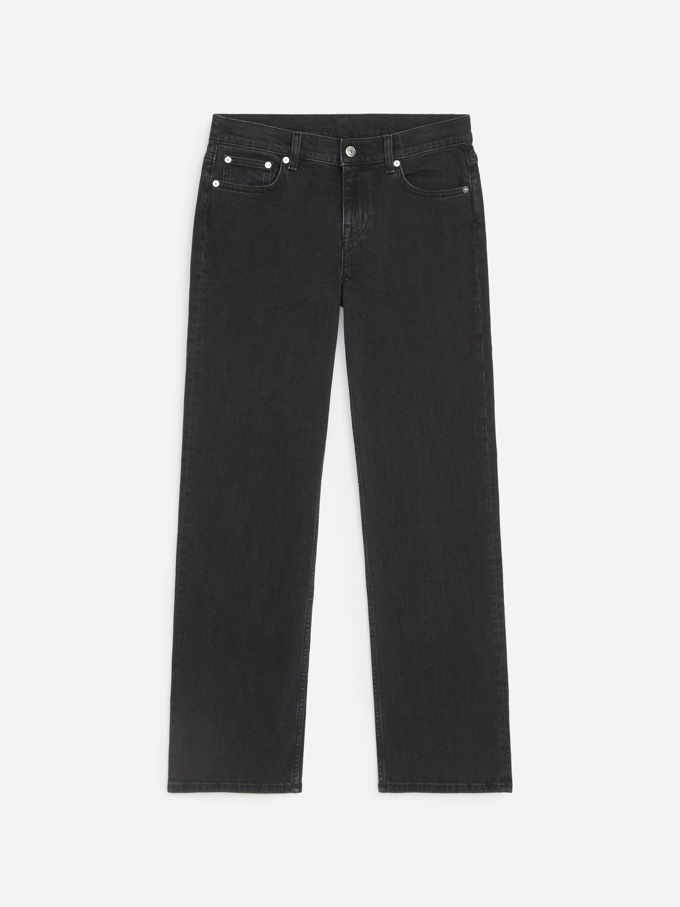 La modelo lleva unos vaqueros negros de pierna recta con corte slim. Los vaqueros se combinan con una camiseta blanca por dentro, una chaqueta de cuero negra abierta y unos mocasines negros.