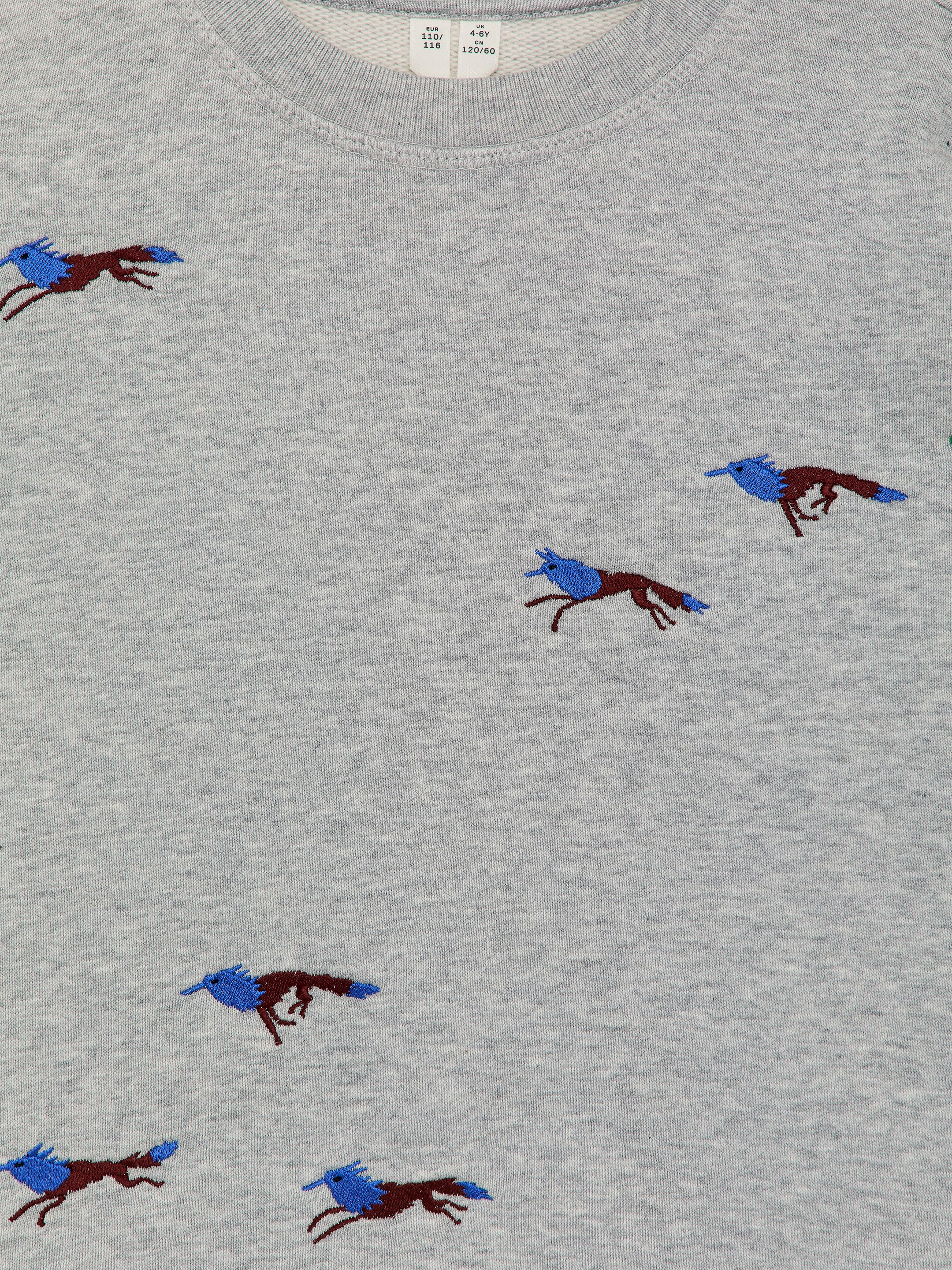 Προβολή μεγαλύτερης εικόνας: Ένα γκρι φούτερ με στρογγυλή λαιμόκοψη εμφανίζεται από μπροστά, με ριγέ γιακά και διάσπαρτα κεντημένα στυλιζαρισμένα ζώα που τρέχουν με καφέ σώματα και μπλε κεφάλια και ουρές. Προβάλλει μια υφή από βαμβακερό τεριέ βαρέως τύπου.