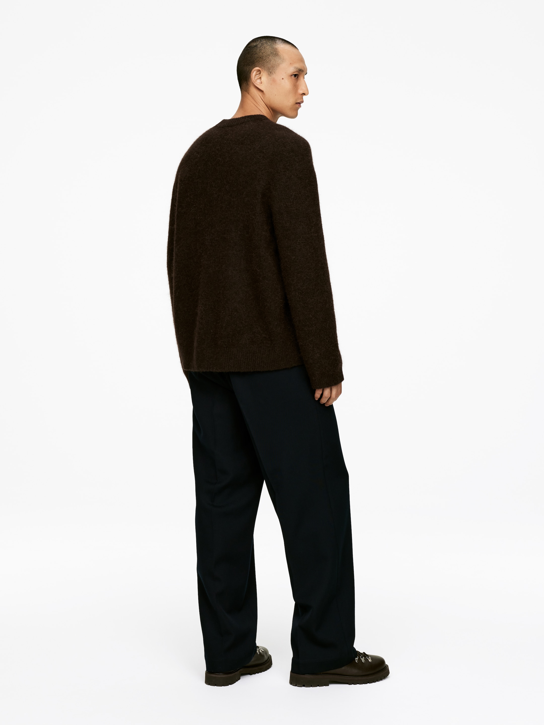 Agrandir l'image: Un pull marron foncé est présenté en vue arrière trois-quarts, avec une coupe ample et décontractée, une texture en maille brossée, des manches longues, un col rond, et des poignets et un ourlet côtelés.